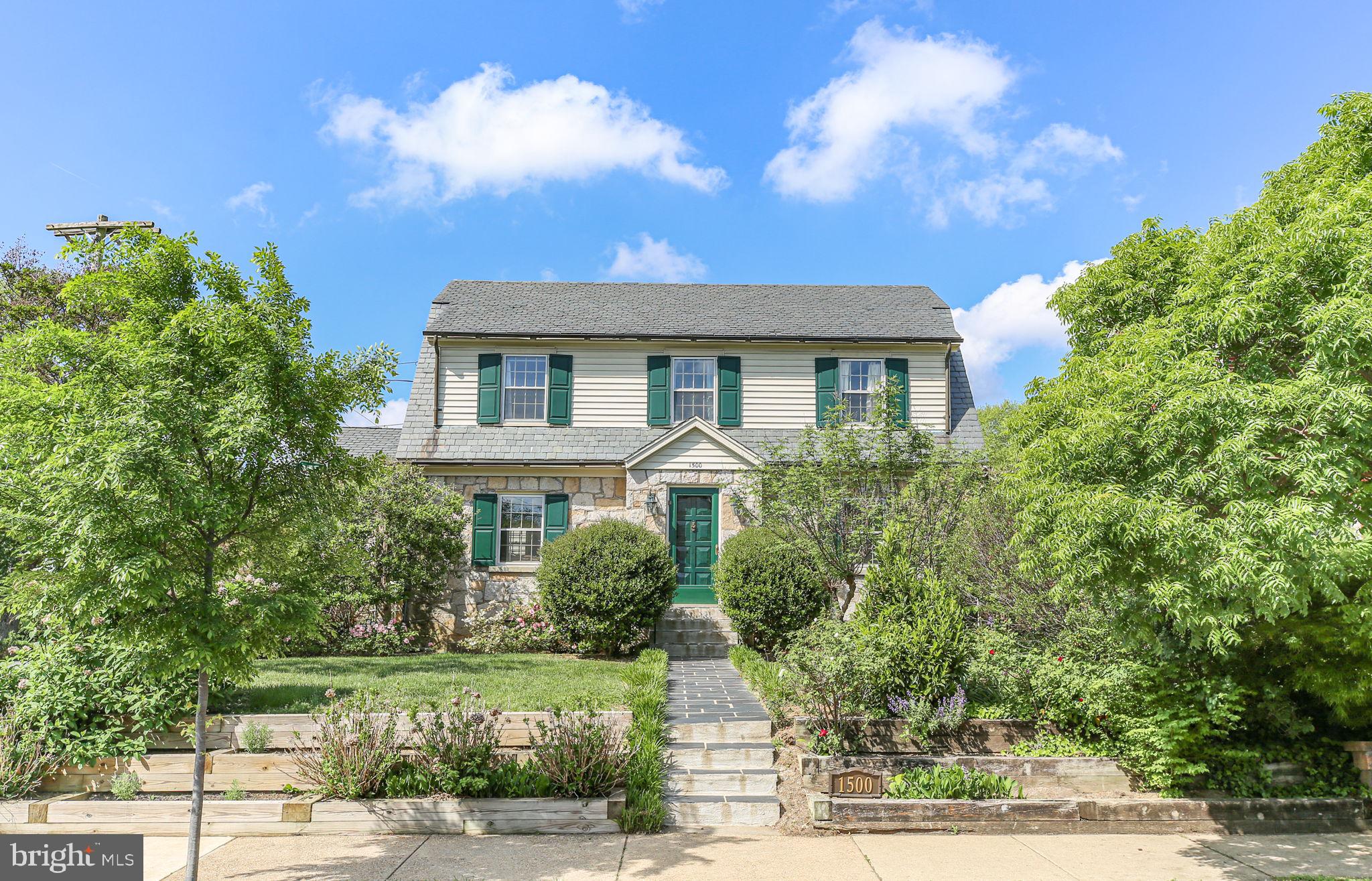 Nestled in the heart of the sought-after College Heights neighborhood near University of Mary Washington, 1500 Augustine Avenue is a timeless treasure filled with character, warmth, and thoughtful updates. Built in 1940, this charming historic home blends classic architectural details with flexible modern living. From the copper gutters and slate roof to the stone façade and mature landscaping, every inch of this property welcomes you home.

A charming walkway winds through lush gardens to the side entrance, where the breezeway connecting the original home to the addition creates the perfect everyday entry. To the left, the thoughtfully designed addition offers exceptional flexibility — currently used as a spacious Family Room, yet equally suited as a luxurious main-level Primary Suite. This inviting retreat features a newly renovated spa-inspired bathroom with dual vanities, custom tile work, a corner soaking tub, and gleaming corner shower with dramatic vertical tile detail. A large walk-in closet provides abundant storage, while private access to the deck and patio creates a peaceful connection to the outdoors.

The backyard is truly a sanctuary, complete with mature shade trees, flowering shrubs, perennial gardens, a detached shed with potting space and storage for tools and toys, plus a charming playhouse ready to delight once again.

Back inside the main home, vintage charm shines throughout. A quaint powder room on the right feels delightfully true to the home’s 1940 roots, while the light-filled kitchen offers generous prep space, ample cabinetry, sunny backyard views, and lovely display shelving above the cabinets. The formal Dining Room is ideal for gatherings and showcases beautiful built-in display shelves perfect for treasured collections.

A welcoming front foyer opens into the center hallway and leads to the gracious Living Room — a space that instantly feels like home. Just beyond, a warm and inviting library features a cozy gas fireplace, built-ins for books and keepsakes, and access to a shady elevated porch perfect for relaxing and watching the neighborhood pass by.

Upstairs, the spacious primary upper-level bedroom is filled with natural light from abundant windows. Two additional bedrooms, a charming seating nook, and a vintage full bath with classic tilework complete the second level.

The lower level provides even more versatile living space with a comfortable Recreation Room/Den featuring additional built-ins, a beautifully renovated third full bath, and a legal fifth bedroom currently used for storage. With its separate exterior entrance, sitting area, and kitchenette space, the lower level offers exciting possibilities for guest quarters, apartment-style living, or multi-generational flexibility.

This home has been lovingly maintained and recent improvements are available to your agent through Agent Remarks -- ask them all about it for your peace of mind. 

Located in beloved College Heights, residents enjoy tree-lined streets, architectural charm, and exceptional walkability. Explore downtown Fredericksburg’s shops, restaurants, galleries, and riverfront parks, all just minutes away. Convenient access to medical facilities and the Virginia Railway Express makes commuting and everyday living effortless.

Visit today and fall in love with this rare historic gem.