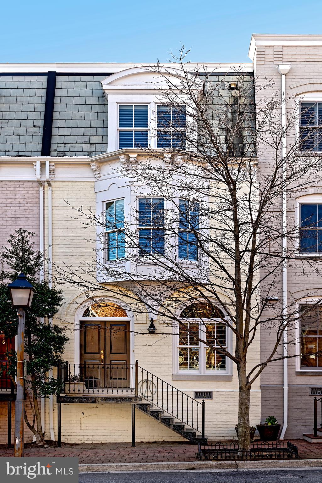 120 Queen Street in Queens Row offers the perfect city location, close to Founders Park, the Potomac River and to the fine restaurants and interesting boutiques on King Street.  Walk to everything while you park your cars in two deeded parking spaces.  This light and bright brick townhouse features beautiful hardwood floors throughout all three levels, handsome detailed moldings, high ceilings, tall windows and spacious rooms for entertaining.  Two gas fireplaces add to the ambience of both the living room and the second floor family room.  The kitchen with recent Samsung Chef's Collection stainless appliances offers gas cooking and neutral backsplash.  The large breakfast room is inviting with double glass doors into the hallway.  The family room with gas fireplace and built-in bookshelves has a bay window.....you can get a peek at the river from this bay window.  The master suite is flooded with natural light, offers his and hers walk-in California closets and a renovated master bath.  Two guest en suite bedrooms and a laundry room complete the top floor.  The southern facing patio has a Walpole white fence....the highest quality you can find.