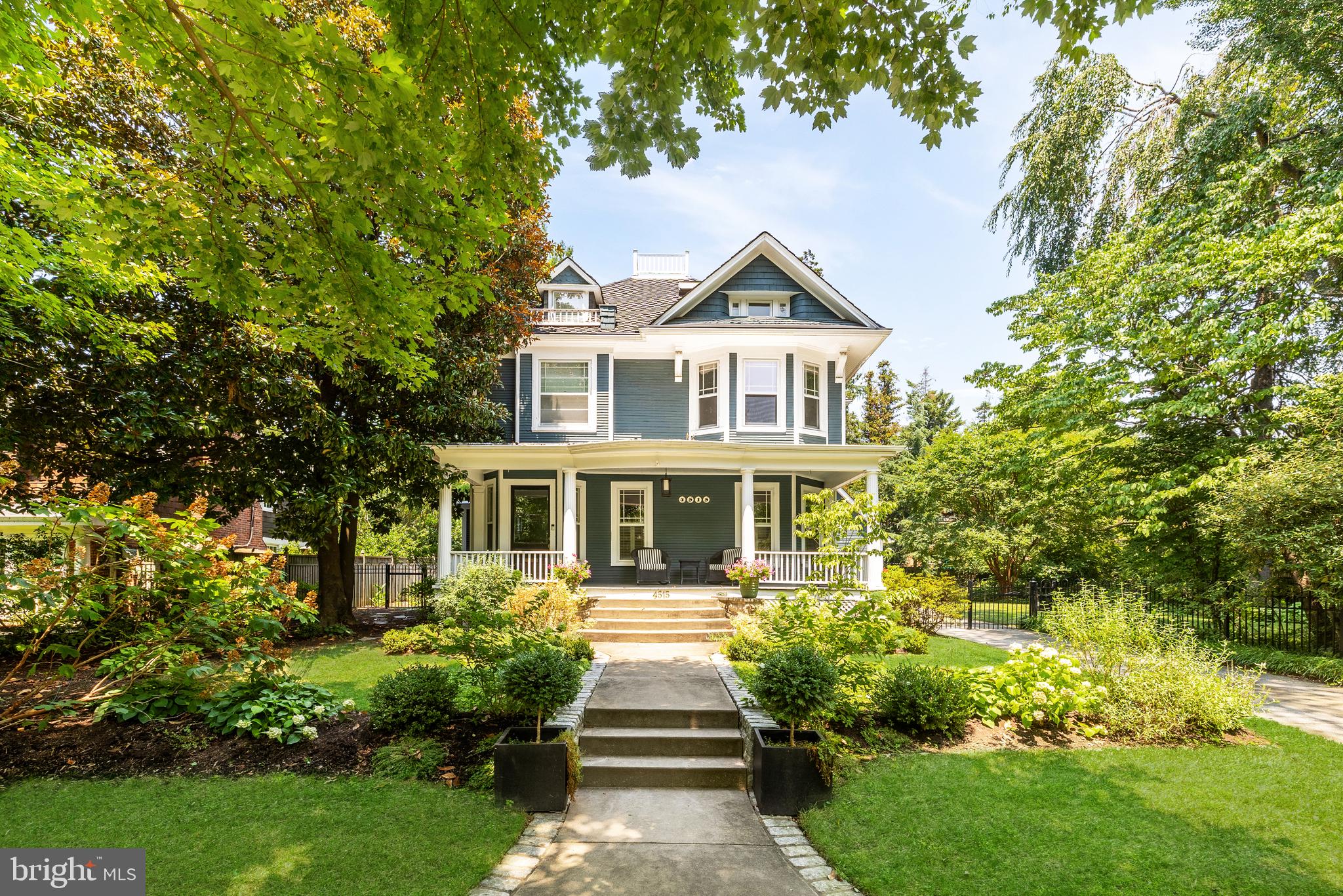 Tucked away off of Wisconsin Avenue adjacent to the Chevy Chase Club is 4515 Drummond Avenue, an original 1900 Victorian nestled in a tranquil, verdant setting within the Village of Drummond. Situated on a RARE DOUBLE LOT WITH DEVELOPMENT OPPORTUNITY, the home represents a once-in-a-lifetime offering within a truly unparalleled location – an equidistant ten-minute walk to either Downtown Bethesda or Friendship Heights. Having undergone a thorough transformation in 2019, there has been a seamless integration of modern livability while retaining every bit of historic character. The facade’s soothing nautical palate with contrasting white trim evokes effortless elegance and augments curb appeal from one of the neighborhood’s most picturesque streets. Traversing the full-width southern-facing front porch, a refined reception foyer introduces a floor plan equally adept at accommodating formal entertaining as it is casual daily needs. Intricate original millwork accents the space, which opens into the formal living room with a roaring gas fireplace. An original pocket door creates seamless flow between the living room and a large den with built-in bookcases, itself adjacent to the large formal dining room. In the home’s more informal area, the chef’s kitchen is skylit from soaring cathedral ceilings. White shaker cabinetry, a large contrasting island, and a full suite of professional gas appliances greatly enhances the functionality of the space. The large adjacent dining area features a cozy wood burning fireplace and opens to both the patio as well as a stunning screened-in porch via 12-foot accordion doors. Direct access to the attached garage completes the main level. Upstairs, the spectacular primary suite was newly created during the renovation and is a sumptuous retreat. Its ensuite bath is clad in Carrara marble and features dual vanities, a walk-in shower, radiant heated floors, and a stylish freestanding soaking tub. Dual walk-in closets with extensive custom built-ins round off the extensive list of amenities. Two additional bedrooms on the second level are ample in scale, include custom closets, and share a luxurious marble bath. The top level includes two more bedrooms sharing another large bath with dual vanities and a walk-in marble shower, as well as a cedar closet. The finished lower level includes a recreation room with built-in seating, a fitness center, laundry facilities, and powder room. Out back, a whimsical combination of meticulous hardscaping and landscaping harmonize in a natural oasis, fully fenced and surrounded by mature foliage for total privacy. Slate patios and stone retaining walls surround the 32-foot pool, fully refinished in 2021. A meandering gravel path connects the hidden side yard with fire pit and custom pond, an ideal space for outdoor entertaining on warm summer evenings. Having gone beyond skin deep, the renovation included new HVAC systems, wiring, recently installed tankless water heater, and twin 240-volt EV chargers in the garage, whose upper level is framed with electrical rough-ins for a future bonus space. Blocks to schools, trails, parks, and public spaces, 4515 Drummond Avenue is the quintessential home in one of the Capital Region’s most sought-after locations.