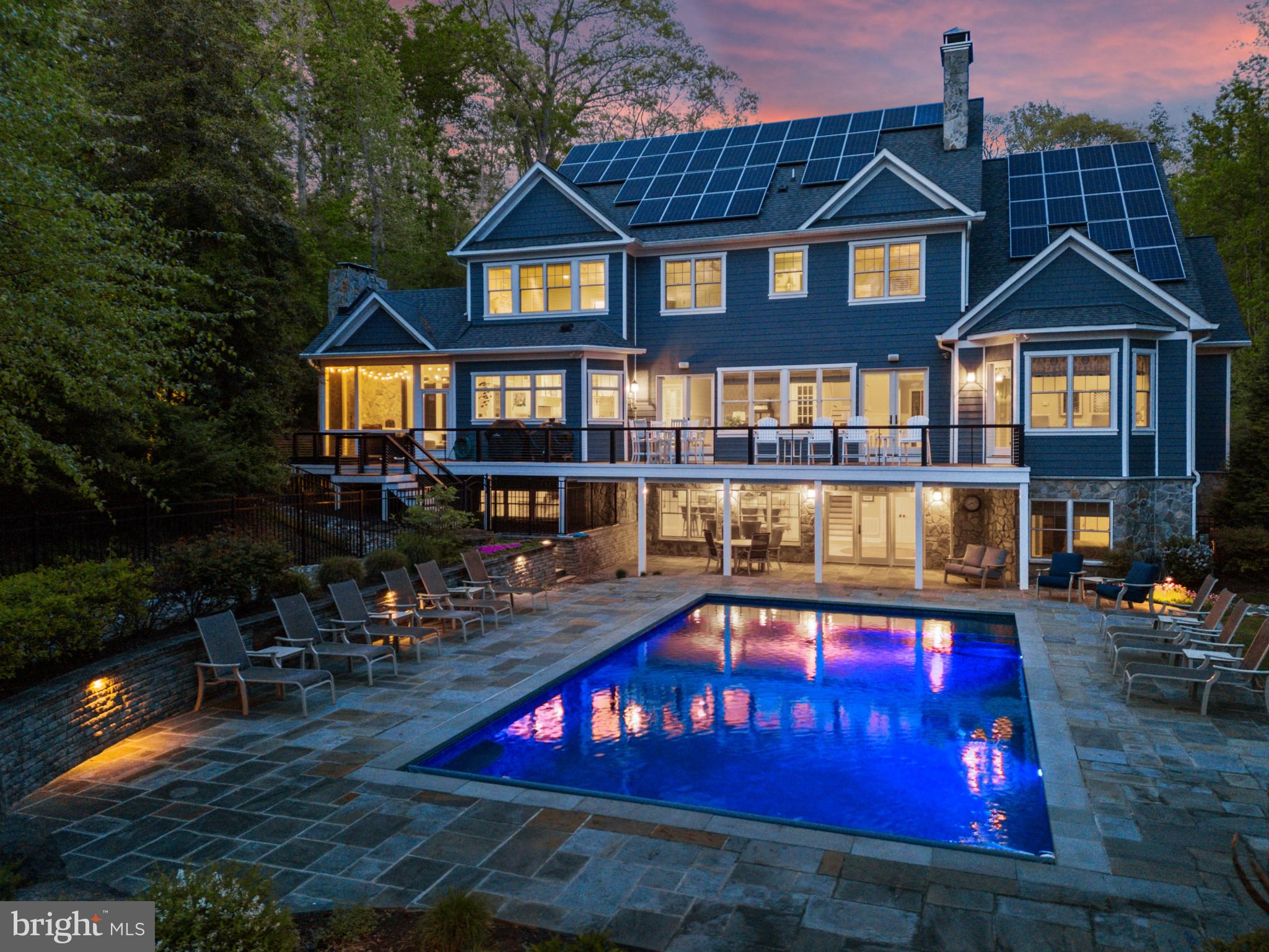 Stunning coastal waterfront home with pool has everything you are looking for in a forever home! Experience peace of mind whether home or away while residing in this gated property featuring 8600+ sqft across 3 sprawling floors with one level living option providing flexibility and luxury living at its best! The combination of low maintenance finishes, smart design and stunning interior architectural details offers the best of both worlds; comfortable living with all the modern conveniences to enjoy the everyday AND generously sized spaces both inside and out to accommodate gatherings of all sizes. The screened porch with wood-burning fireplace and pizza oven adjacent to the expansive rear deck with recessed hot tub and the lower level patio with heated, saltwater swimming pool with automatic cover maximizes outdoor entertaining. A picturesque setting, elevated and nestled amongst the trees, while still optimizing waterfront living  with a private pier, boat lift and multiple slips on a protected creek with easy access to the South River and Chesapeake Bay. Custom built and constructed in 2016, it is evident that no expense was spared! This turn-key property features hardwood hickory floors, elaborate millwork, high-end finishes and tall ceilings throughout. The main level boasts a luxurious Primary suite with vaulted ceiling, pool view and spa-like bath with glass enclosed shower, bubbler tub for the ultimate in relaxation and double vanities for convenience. The deluxe Chefs Kitchen with island and high-end appliances, coffered ceiling Living room with fireplace, dining area, home office/bonus room, powder room and spacious guest room with ensuite bath highlight the elegance of this home.  The upper level is adorned with 4 additional bedrooms, 2 adjoined by shared bath, 1 with ensuite bath that also services the 4th bedroom, sitting area and the fabulous oversized playroom/bonus room. The lower level is devoted to fun and leisure with a fully-equipped bar with seating, rec room area with fireplace, gym, and private guest room with ensuite bath. This property is located in the South River school district and it is the ideal location for quickly accessing the South River or Chesapeake Bay by boat, heading by car to Historic Annapolis or hopping on Rt. 50 to get back to Washington, DC. Escape to this waterfront oasis on Gingerville Creek!  Welcome Home!