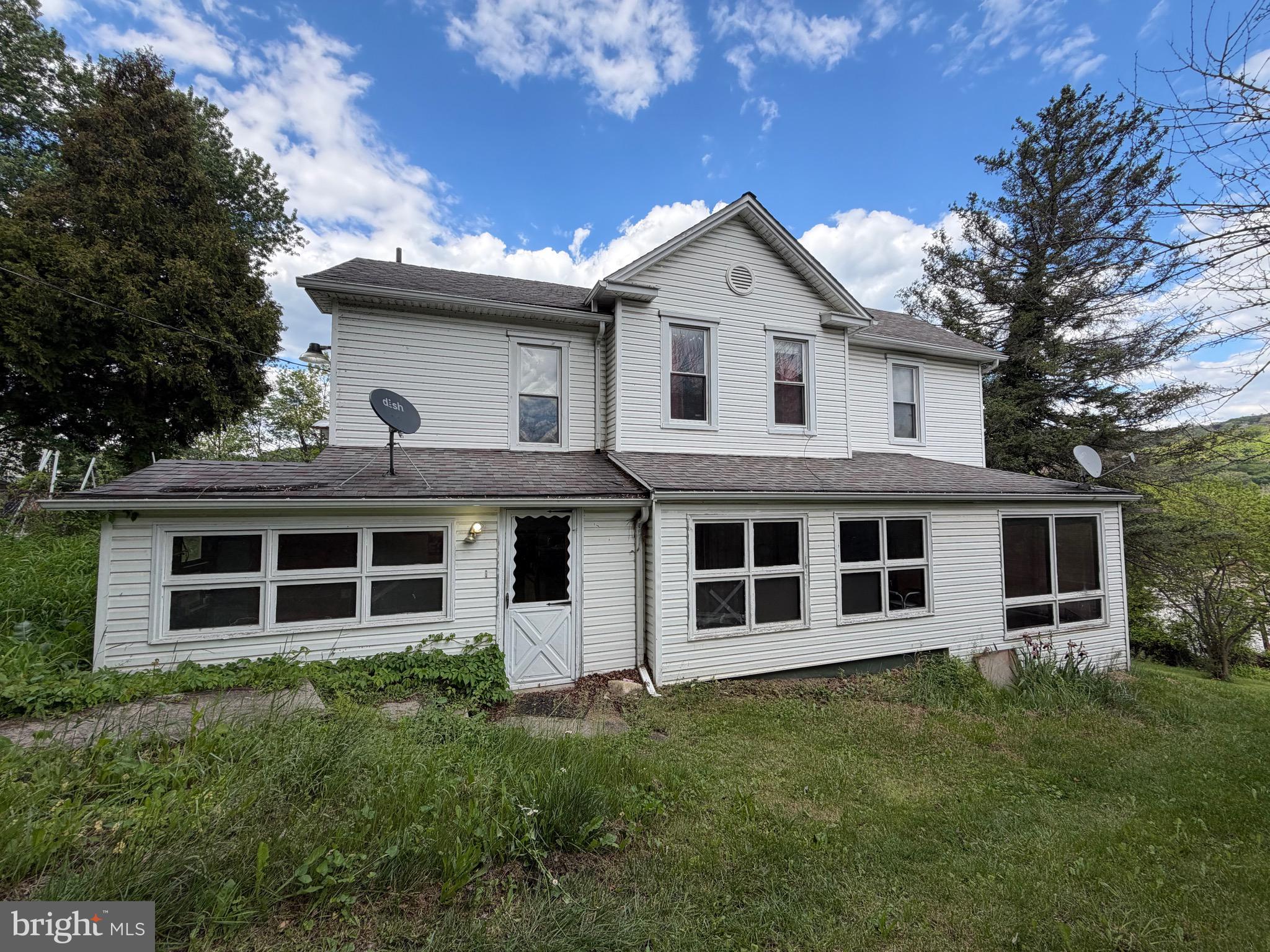 This spacious farmhouse is full of potential and ready for its next owner to restore it to its former charm! With separate electric meters for the upper and lower levels, the possibilities are endless — convert it into a two-unit investment property or enjoy it as one large family home.

The upper level features a kitchen, full bathroom, and four spacious rooms that could serve as bedrooms, an office, living area, or flex space to fit your needs. The lower level offers a kitchen, dining room, full bathroom, laundry/utility room, family room with a cozy wood stove, and two additional rooms that could be used as bedrooms, a living room, or extra entertaining space.

Used as a single-family residence, this home could easily accommodate 5–6 bedrooms!

Outside, you’ll find a welcoming front porch, side porch, rear deck, huge fenced backyard, plenty of parking space, and a garage — offering room to relax, entertain, and enjoy country living.