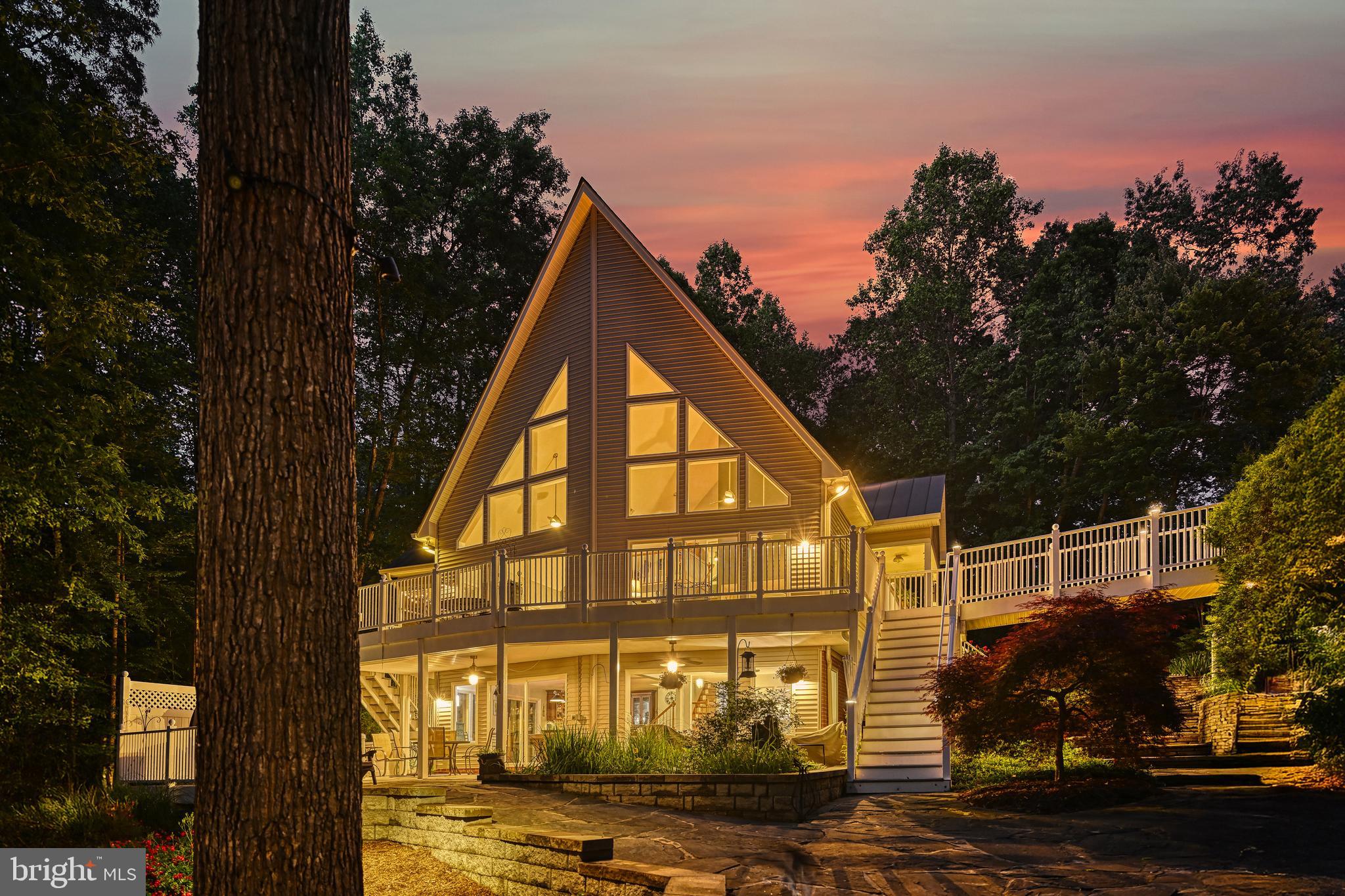 Check out this amazing Contemporary Style Waterfront Home with impressive hardscape and landscaping! Located in premier Magnolia Harbour neighborhood, this 5 bdrm (3 bdrm septic) home is loaded with upgrades from the 24 ft. pitched window wall featuring lake views, solid American cherry hardwood flooring on main and upper levels, engineered hardwood flooring on the lower level and solid core room entry doors. The main floor includes a 22 ft. long primary suite with private balcony, custom walk-in closet and ensuite with large 2-head shower and granite counter with double vanity!  The large gourmet kitchen boasts quartzite countertops and cabinetry on all four sides and an island featuring a prep sink, not to mention kitchen aid appliances including double wall ovens and under counter drawer microwave. On the lower level you will enjoy a large Rec Room with Custom Bar, large Laundry Room, a hobby room, two full bedrooms and a full bathroom with double vanity. On the upper level you will discover two more bedrooms, another full bathroom with double vanity and a loft area with great water views! Additional features for this home include a full water treatment system, hot tub adjacent to a covered patio, hot/cold outdoor shower and 23x35 oversized detached garage with an unfinished second level. At the 227 ft. shoreline, you will find a large (1200+ sq. ft.) boat dock with two slips both including electric boat hoists, a kitchen/bar with hot and cold water and a dedicated large storage area. Back at the house, you can enjoy your morning coffee or evening drink from a multitude of outdoor choices…the main level full length sundeck, one of the lower-level covered porches, the screened porch or even the primary suite private balcony. So many more features with this property! Be sure to check out the pictures and Virtual Tour.