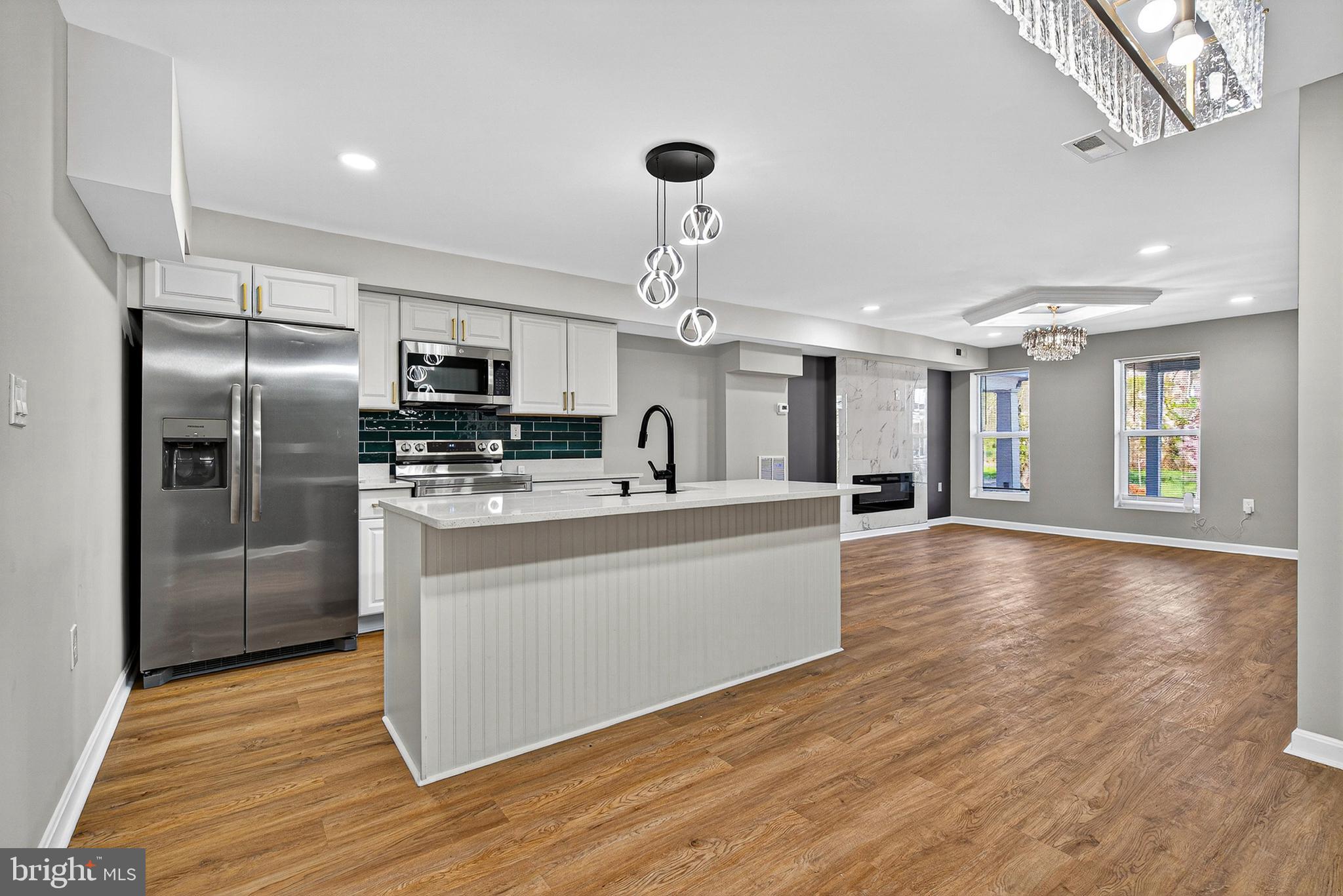 Experience the pinnacle of modern city living in this masterfully renovated 5-bedroom, 3.5-bathroom residence. Situated in the heart of Baltimore, this home seamlessly blends contemporary architectural elements with functional luxury, offering an expansive floor plan designed for both high-end entertaining and everyday comfort. New plumbing, electrical, HVAC, flooring etc. Proiperty has its own parking spot.
Step through the entry into a light-filled, open-concept sanctuary defined by high ceilings and wide-plank flooring. The living salon serves as a stunning focal point, anchored by a floor-to-ceiling marble-clad fireplace flanked by contrasting charcoal accent walls. Above, a recessed tray ceiling with an integrated crystal chandelier adds an undeniable touch of grandeur.
The transition to the dining area is marked by a bold, forest-green slat-wall installation, illuminated by a linear geometric chandelier—a true statement piece for formal gatherings. Designer Cabinetry , Crisp white Shaker-style cabinets accented by brushed gold hardware. Pristine white quartz countertops and a waterfall-edge breakfast island. A deep emerald subway tile backsplash and a matte black gooseneck faucet.  A full suite of high-end stainless steel appliances, including a built-in microwave and French-door refrigerator.
With five generously sized bedrooms, including a primary suite that acts as a private retreat, this home offers unparalleled versatility. Custom floor-to-ceiling tile work with intricate geometric and marble motifs. Matte black designer fixtures and circular vanity mirrors. Frameless glass showers and deep soaking tubs.
Fully Finished Lower Level: Additional living space perfect for a media room, home gym, or guest suite.
Dedicated Laundry room, featuring high-efficiency appliances. A classic Baltimore front porch and a rear deck, ideal for evening relaxation. All-new mechanicals, recessed LED lighting throughout, and premium finishes at every turn.
3023 W Garrison Ave is more than a home—it’s a lifestyle statement. Schedule your private tour to experience this Baltimore gem in person.