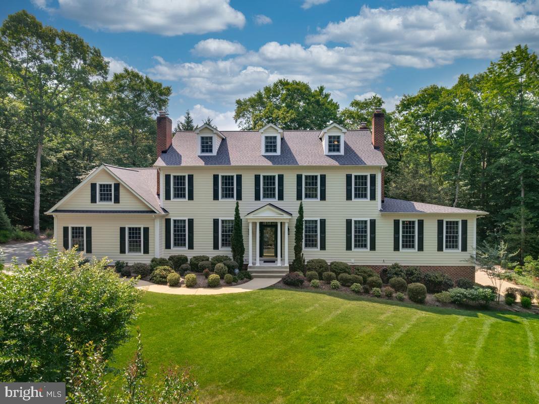 Nestled on a quiet cul-de-sac in a private, picturesque setting, this impressive Colonial-inspired estate offers timeless grandeur, exceptional craftsmanship, and over 7,200 square feet of elegant living space designed for both entertaining and everyday comfort. A stately presence and grand entrance welcome you into a home filled with architectural details rarely found today. Ten-foot ceilings, extensive crown molding, chair rail, wainscoting, custom built-ins, and exquisite woodwork create warmth, character, and sophistication throughout. Designed for hosting on any scale, the formal living room and formal dining room each feature a working fireplace with custom mantels. The dining room is complemented by a true butler's pantry with floor-to-ceiling shelving nearly 10 feet high, creating a seamless connection to the beautifully updated kitchen. Home chefs will appreciate the expansive workspace, granite countertops, double ovens, abundant cabinetry, and effortless flow into the spacious family room with a gas fireplace and extensive built-in bookcases. Just off the family room is a private office, while a substantial addition offers incredible flexibility. Previously used as a successful home business, this space includes a full bath and office area and could easily serve as a main-level primary suite, guest quarters, or multi-generational living space. 
The second level is highlighted by an exceptional primary suite featuring its own wood-burning fireplace and an extraordinary walk-in closet with a footprint comparable to the three-car garage below. The spa-inspired en-suite bath offers a soaking tub, separate shower, dual vanities, and access to an adjoining room currently used as a dressing room, but equally suited as a private study, nursery, or additional bedroom. Two additional spacious bedrooms with custom built-ins share a well-appointed full bath, completing this thoughtfully designed level. The third floor provides even more living space with two additional bedrooms, individual mini-split HVAC systems for comfort and efficiency, and a shared full bath. The fully finished lower level is ideal for entertaining, extended family, an au pair suite, or in-law apartment. Complete with a full kitchen, recreation room, full bath, den or sleeping area, exercise room, and generous storage, the space opens directly to a large screened porch overlooking the gardens and outdoor entertaining areas.
With four working fireplaces, a three-car garage, an extended driveway with ample parking, and endless possibilities for home business, multi-generational living, or gracious entertaining, this remarkable estate offers a rare combination of elegance, functionality, and enduring charm.  Located  in Northern Charles County, just minutes from major commuter routes to Washington DC.
