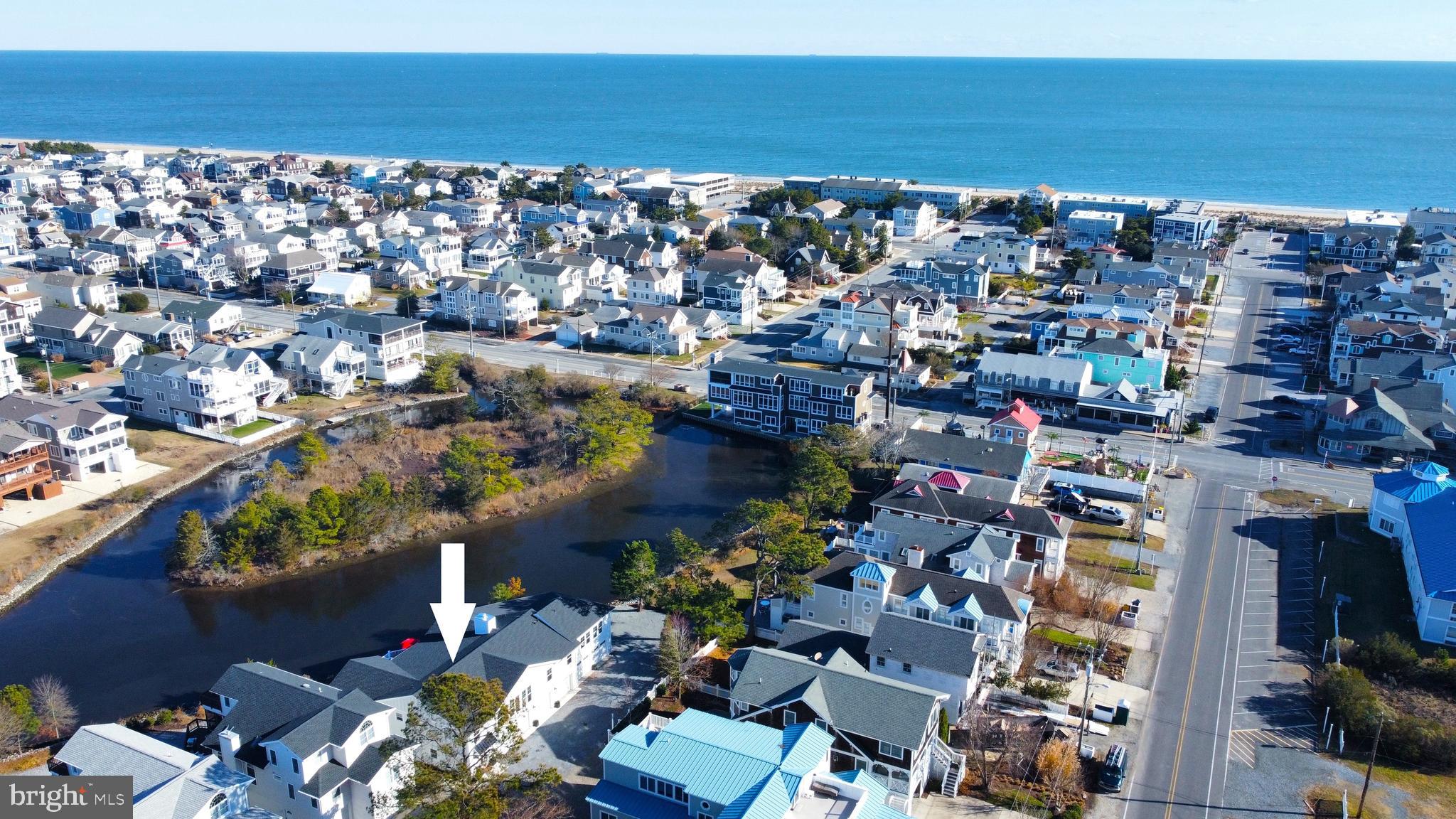 Stunning oceanside retreat positioned directly on the water’s edge of the peaceful and picturesque Bethany Loop Canal—just two blocks from the sand and surf in downtown Bethany Beach! Complete renovation of the property, both inside and out, was finished in November 2025... nearly everything is new! Boasting nearly 4,000 square feet of finished living space, this sprawling home has been elegantly transformed, blending timeless architecture with sophisticated coastal style. The exceptional 5-bedroom, 5-bath (3 full and 2 half) residence is designed for effortless relaxation and memorable gatherings. The main level features an expansive open floor plan that combines multiple living areas, providing abundant room to unwind, entertain, and enjoy the tranquil waterfront setting. The gourmet kitchen is as functional as it is beautiful, offering quartz countertops, crisp white cabinetry, stainless steel appliances, and a large island with seating. The luxurious primary suite provides a serene escape, complete with a spacious sitting room overlooking the canal—perfect for unwinding after a day at the beach. A large upper deck invites you to enjoy the warm coastal breezes, sweeping water views, and frequent heron sightings. The ground level includes a welcoming foyer with custom built-in cabinetry, along with a second laundry area featuring new oversized front-loading washer and dryer units, an additional refrigerator, and a utility sink. A rare find in Bethany, the property also includes an extraordinary 5-bay garage with space for up to seven vehicles, providing over 2,500 sq feet of secure covered parking and storage. Additional updates to the home include all-new flooring, new lighting, new roof, new HardiePlank siding, new windows, four new HVAC units, a dedicated Tesla car charger, new outdoor shower, and a state-of-the-art security system with full remote capabilities. Outside, the spacious lot boasts a private oversized parking area, plus a large grassy backyard with custom plantings—perfect for inspired gardening, entertaining, and relaxing. Offered fully furnished with designer selections, this immaculate retreat is ready to be enjoyed from day one. Positioned on the desirable east side of Route One with a clear town-owned walking path to Pennsylvania Avenue, residents and guests can easily walk directly to the beach and into town without needing to travel along Route One. Tucked away at the end of a quiet cul-de-sac, this property offers incomparable privacy while also being just steps from all Bethany has to offer—the beach, boardwalk, restaurants, and shops. Occupying the footprint of three town lots (non-subdividable) combined to create one remarkable homesite, this property enjoys a level of space and exclusivity rarely available this close to the beach. Park your car and experience the very best of Bethany Beach living—privacy, convenience, and coastal charm, all in one extraordinary property.