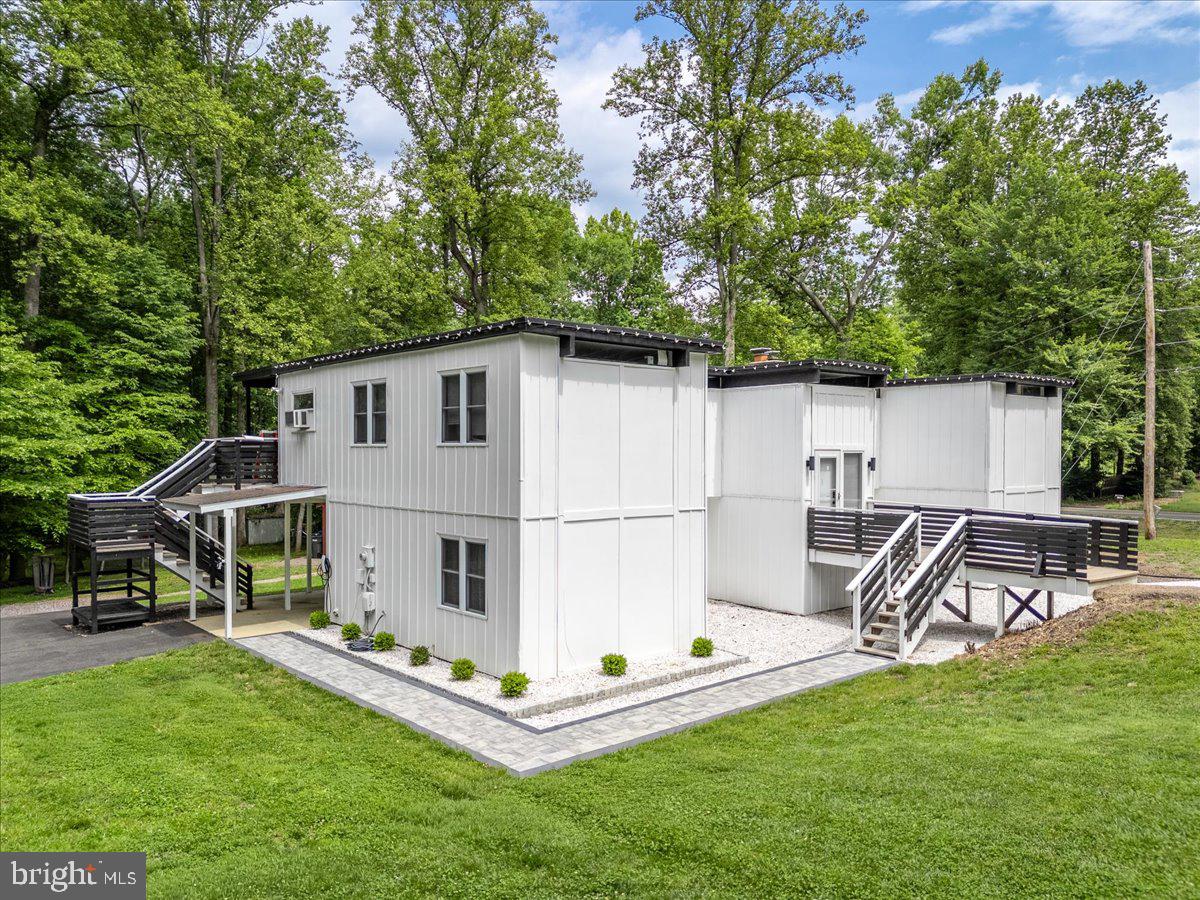 Welcome to 7200 Ridgeway Dr, a beautifully improved 5-bedroom, 3-bath home in Oak Ridge Estates on over half an acre with mature trees, privacy, and no HOA. This Mid-Century Modern split-level home offers a bright main living level with an opened kitchen layout, updated flooring, refreshed finishes, and a comfortable flow with plenty of natural light for everyday living and entertaining. The lower level features two bedrooms, a full bath, daylight windows, walkout access, rear/side entrances, and flexible space for guests, work, hobbies, or multi-generational living.

Major improvements include conversion from oil to electric, updated HVAC/AC system, newer electric water heater, newer washer/dryer, updated bathrooms with modern sinks and replaced toilets, updated basement walls and flooring, newer keypad door lock, and drainage improvements with added drains/piping to help redirect water away from the home. Carpet has been removed in key areas and replaced with modern hard-surface flooring. Public water and public sewer. Tesla charger may convey only if buyer has a Tesla; otherwise sellers reserve the right to remove prior to settlement.

Enjoy a private, wooded setting with generous yard space, convenient driveway parking, and a location close to schools, commuter routes, shopping, and everyday conveniences. A rare combination of land, updates, privacy, and flexibility in Manassas.