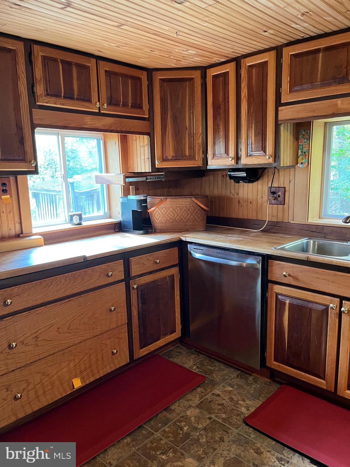 If privacy tops your wish list and character matters more than trends, this hidden woodland retreat delivers. Built as a personal sanctuary by a master cabinetmaker, the home is rich in detail and warmth—with a 600 sq.ft.  detached building  just steps away. It’s rare. It’s real. And it’s waiting. Tucked away, back a 1500' driveway is a 1454 sq.ft. home,  filled with custom woodwork and hand crafted details throughout. The open concept living area flows seamlessly to a beautifully designed kitchen and dinning area,  ideal for gatherings or quiet evenings.  Outdoors, enjoy peaceful surroundings, mature trees, and tranquil breezes  from your hilltop perch.  This property is more than a home.  It's  a personal retreat, a craftsman's legacy and a rare opportunity for those seeking beauty and solitude. Custom built ins and wood finishes throughout.  Heated with 2 wood stoves and propane,  cooled with wall mounted AC units. Walls, ceiling, floors and exterior are all wood.  Recent 50 year metal roof over living  space, and large 27' X 22'  work shop detached from the house.  Work shop could be used for nearly any kind of home based business,  crafts, gym,  detached office space,  art studio,  living space or for  600 sq.ft.  of storage,  with 2  double doors at loading dock height. Has heat and electric, no plumbing.