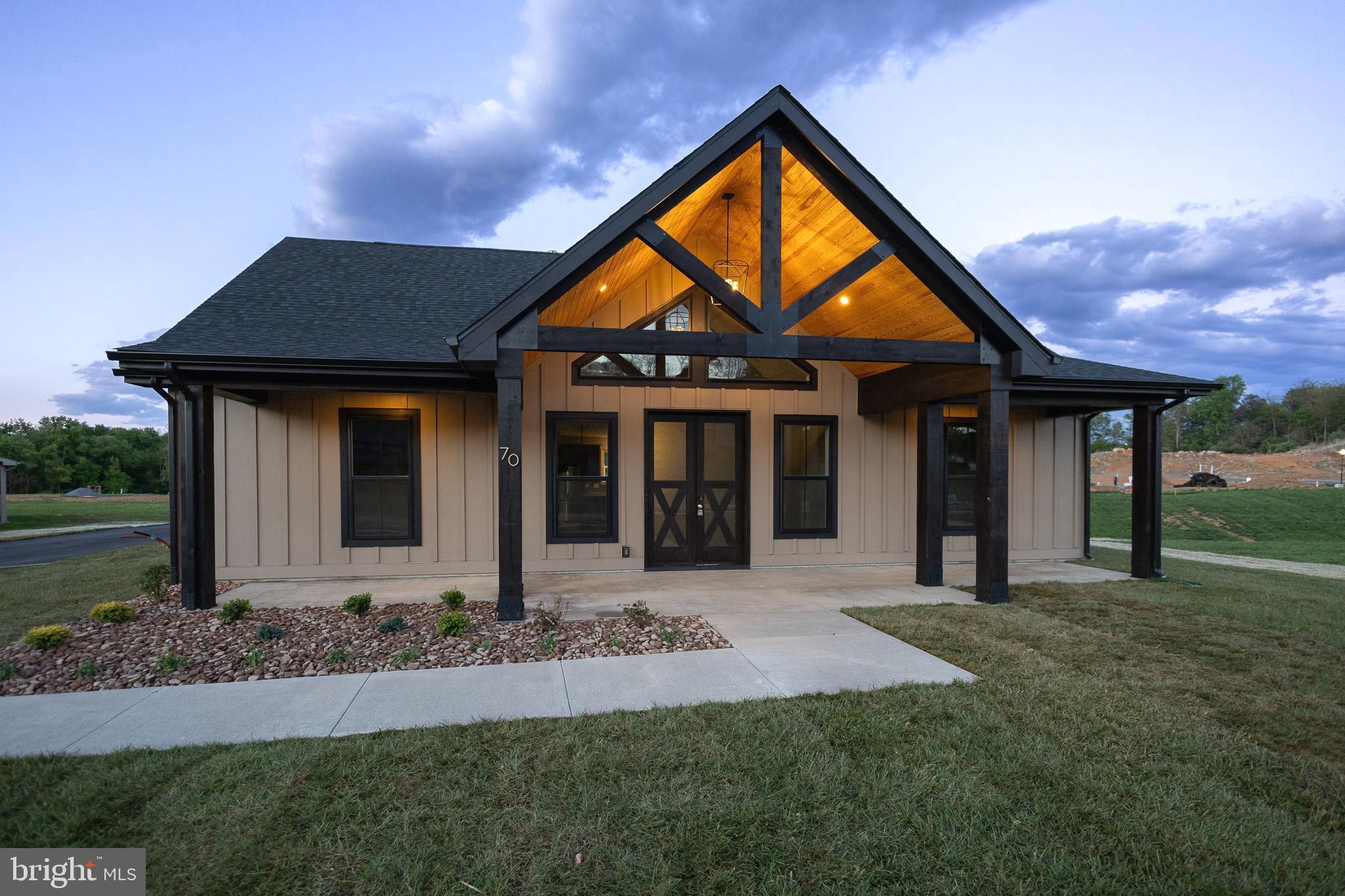 Sitting on three-quarters of an acre in The Reserve at Tuscarora, this stunning luxury-built home, designed by Panhandle Homes of Berkeley County, is now ready for its new owner.  This custom-designed, one-level home shows off an impressive front elevation with a beautiful timber-framed gable, Hardie Plank board and batten siding, and a large front porch.  You’ll be greeted with an open living area with oversized windows and a stone fireplace as you walk through the front French doors.  The gourmet kitchen has upgraded stainless steel appliances, a large center island, quartz countertops, ceramic tile backsplash, and a walk-in pantry with wooden shelving.  The primary bedroom shows off a tray ceiling and large windows, and a sliding glass door to a large, covered rear porch.  The owner’s bathroom has a ceramic tile floor, custom cabinetry, a bench with storage, and a large walk-in tile shower with a stone mosaic floor!  The walk-in closet is massive with a window for natural light and plenty of wooden shelves for organization.  The additional two bedrooms are on the opposite side of the home, separated by a large guest bathroom with a dual bowl vanity.  This home also has a dedicated laundry room with a laundry sink and cabinetry along with an oversized two-car, side-load garage, which has an insulated mechanical closet.  Home comes with a 1 year builders warranty.  Home has public water and sewer, electric appliances and a Trane HVAC system.