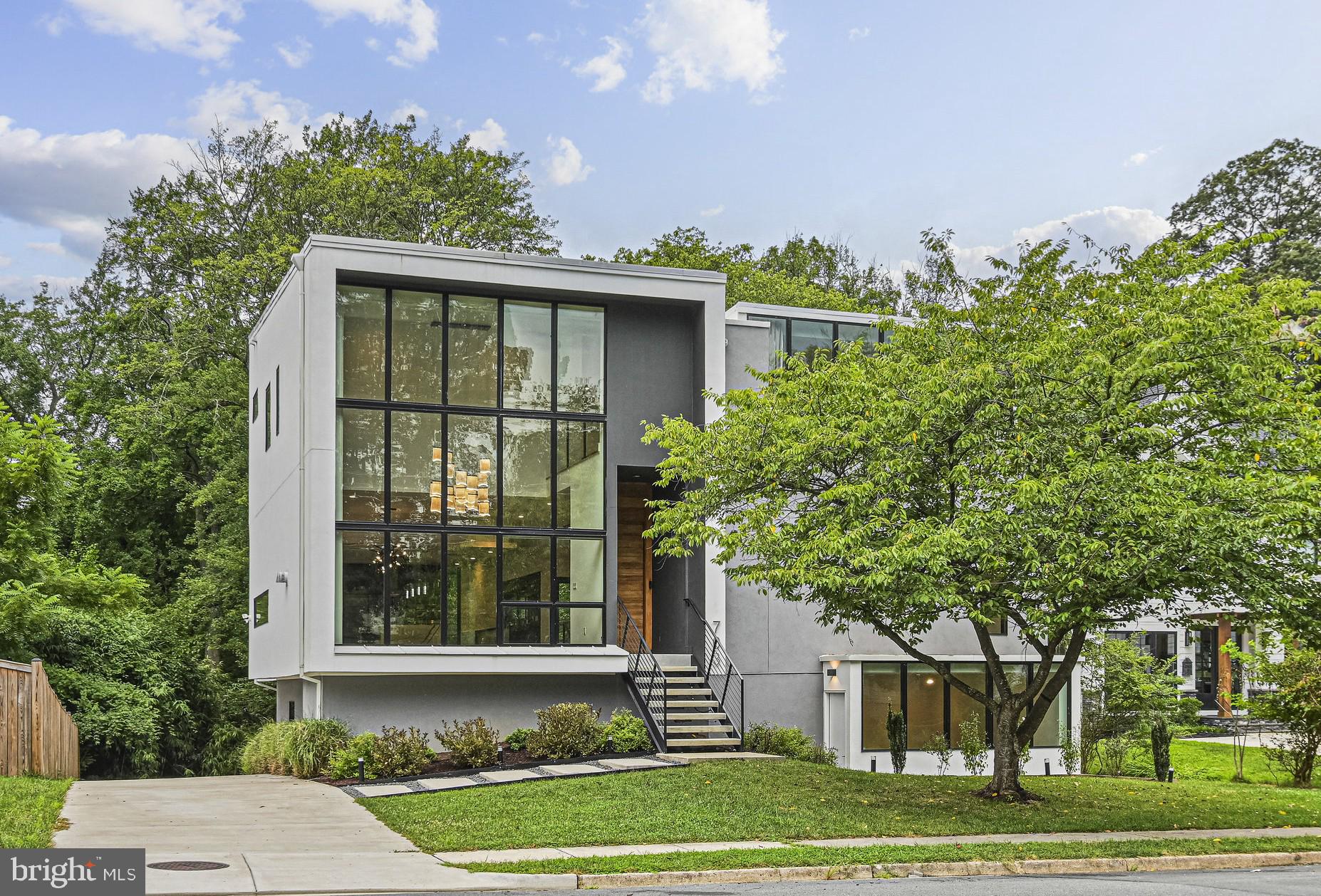 This unique property, known as "The Moment House", offers a blend of modern design, luxurious amenities, and a strong connection to nature. The house is designed to maximize natural light and create "special moments" with a light-filled, open floor plan and floor-to-ceiling windows. Developed by award winning designers at KOR.10 Architecture, Built in 2023, it features 7 bedrooms, Office, 5.5 bathrooms, 2 Car Garage and a spacious 5,650 sq ft interior over three levels .  Nature and daylight engage the home through balconies, decks, patios, and a luxury bathroom lofted above the landscape. Entertaining is made effortless and enjoyable: the kitchen is adorned with top-of-the-line appliances, quartz countertops and European cabinetry with details like built-in cutlery trays and skid free mats in drawers. Additional features include: 45” sink with touchless faucet, 3 side-by-side refrigerators integrated into the cabinets, a demonstration style island with a waterfall top, a counter replete with ice maker and sink serving the outdoor deck through a passthrough window. One level below: an expansive entertainment suite with wine bar and a walk out to the lower patio. The design balances social spaces with the need for peace and privacy: four bedrooms with two sharing the Jack & Jill bathroom, plus the fourth one with its own connected bath, a Primary Bedroom Suite with a dedicated Balcony and a bathroom that is focused on bringing calm and tranquility. A fitness room, an office/study, two guest suites, one with a walk-out cour anglaise all contribute to the need for focused activity and relaxation. Light, shade and shadow on honest natural materials like wood, steel, glass, and concrete are composed to create interest in every part of the house and together as a single composition. Clean lines hide the sophistication integrated into this house from the standpoint of thermal, heating and cooling, reuse and landfill reduction, storm water management and daylighting. Smart systems ingrained into the house make it both easy to use and functional. Great location in Vienna, within couple of miles of the Town of Vienna,  the historic W & OD Trail, Vienna Metro, Meadow Lane Park,  popular Mosaic District, the Tysons Galleria Mall, plus  Nottoway Park which has Basketball, Soccer, Baseball, Tennis, Volleyball courts, trails, Picnic Shelters.  Easy access to ramp for Route 66, Chain Bridge Road, Lee Highway, Vienna, Mosaic, Merrifield Restaurants,  Shopping. Open House this saturday 08/09/25 between 2pm - 4pm