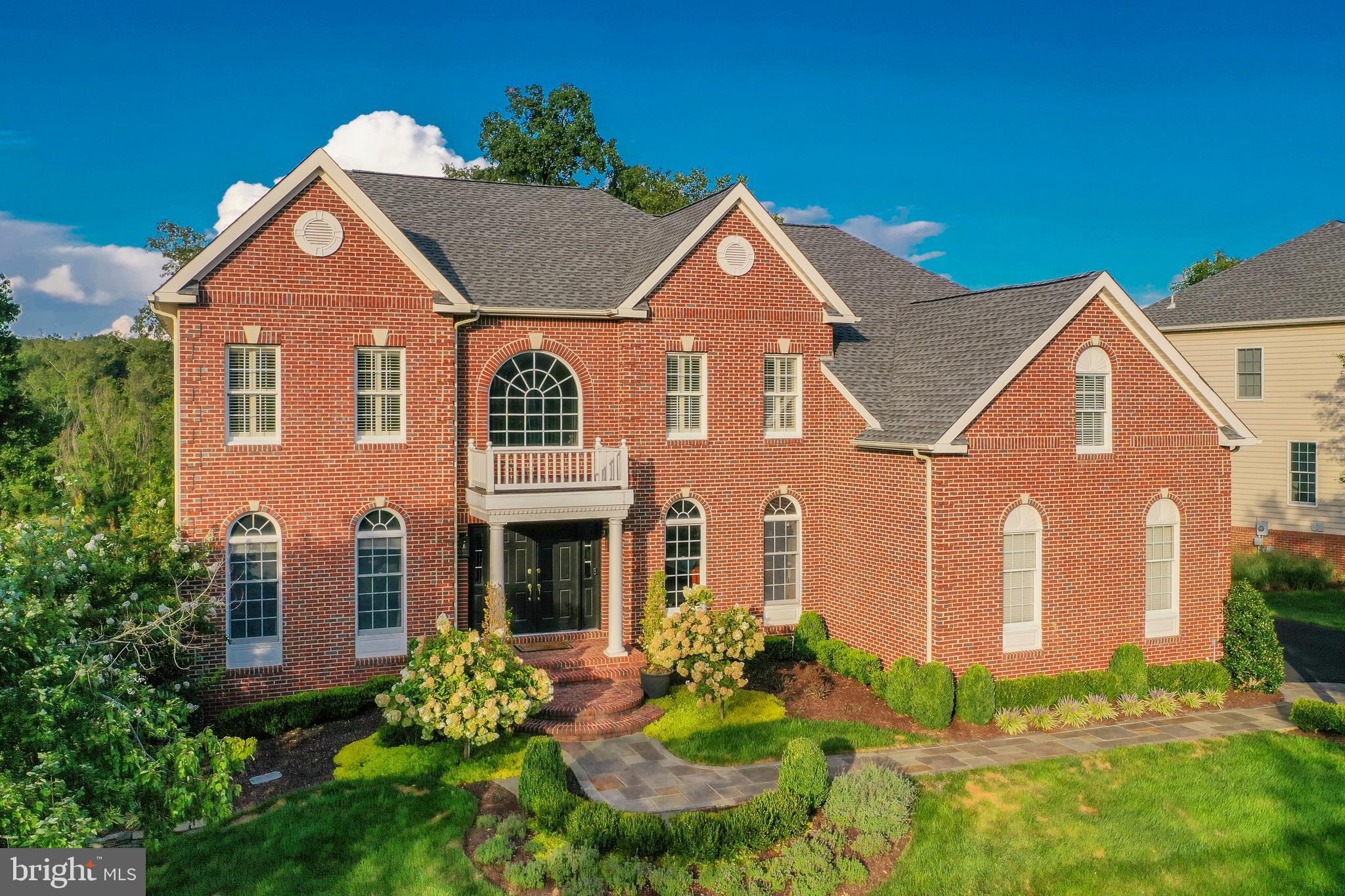 This is an entertainer's dream home - it's all done for you! Absolutely stunning brick front home with incredible high end finishes on an amazing .40 acre lot backing to the 2nd hole in sought after gated Belmont Country Club community. Stone paver walkway leads to covered entry with double front door.  Two story foyer with curved staircase, extensive molding & upgraded light fixture. Elegant living room with wainscoting and formal dining room with wainscoting, extensive molding & upgraded glass chandelier. Expansive family room with floor to ceiling stone fireplace & beverage center with refrigerator.  The open concept floorplan with tons of natural light leads to large kitchen with center island, white & gray cabinetry, upgraded appliances including soon to be installed new gas cooktop, breakfast room extension with walls of windows & rear staircase.  Rarely seen true butler's pantry with custom cabinetry, sink, door to deck & access to the three car garage. The main level also features a private office and beautifully styled powder room. The upper level owner's suite features an expansive 200 square foot walk-in closet & spa like bathroom. Three additional bedrooms and two full bathrooms as well as a conveniently located laundry room with  custom cabinetry & lots of counter space completes the upper level. Totally renovated lower level that includes a wine tasting room with 155 bottle wine cooler, large living area, media room, 4th full bath, exercise room / potential 5th bedroom, large game area suitable for pool table &  wet bar with dishwasher, icemaker, wine refrigerator & kegerator. The large multi-level deck and expansive patio with hot tub overlook the incredible rear yard with mature landscaping, extensive hardscaping & the golf course. Newer flooring on upper two levels, newer roof, heat pump & more. The HOA Fee Includes Lawn Maintenance, High Speed Internet,Cable TV,Trash Removal,Community Swimming Pool,Playground & More.