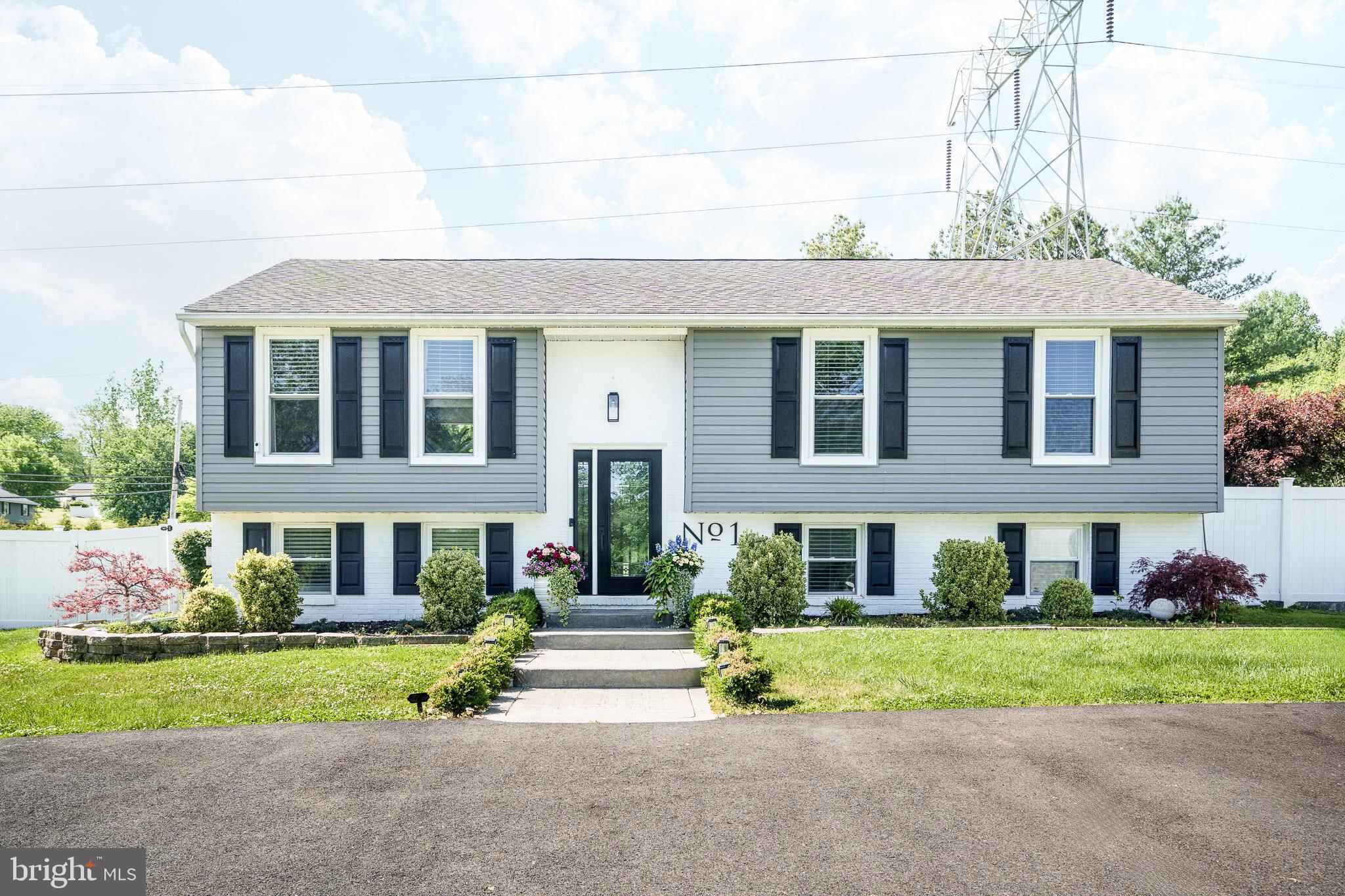 Beautifully renovated home on a spacious fenced lot in Conowingo featuring designer upgrades, flexible living spaces, and an impressive open-concept layout. The stunning gourmet kitchen offers an oversized waterfall-edge island with hidden storage cabinetry, farmhouse sink, gas cooktop with pot filler, custom cabinetry, beverage station with wine refrigerator, and extensive seating and prep space. The bright main living areas feature updated flooring, recessed lighting, and seamless flow for everyday living and entertaining. The finished lower level provides additional living space with a custom fireplace feature wall, built-in shelving, a full bathroom, bedroom options, and walkout access to the backyard. Multiple bedrooms offer flexible layouts, including spaces with built-in desk areas and mini-split systems. The spa-inspired bathrooms showcase custom tilework, oversized glass showers, double vanity areas, and modern finishes throughout. Outdoor features include a large fenced backyard, elevated deck, detached outbuilding, landscaped grounds, decorative garden arbor, and plenty of room for entertaining, recreation, or gardening. Conveniently located with easy access to local commuter routes while offering a peaceful setting with modern updates throughout.