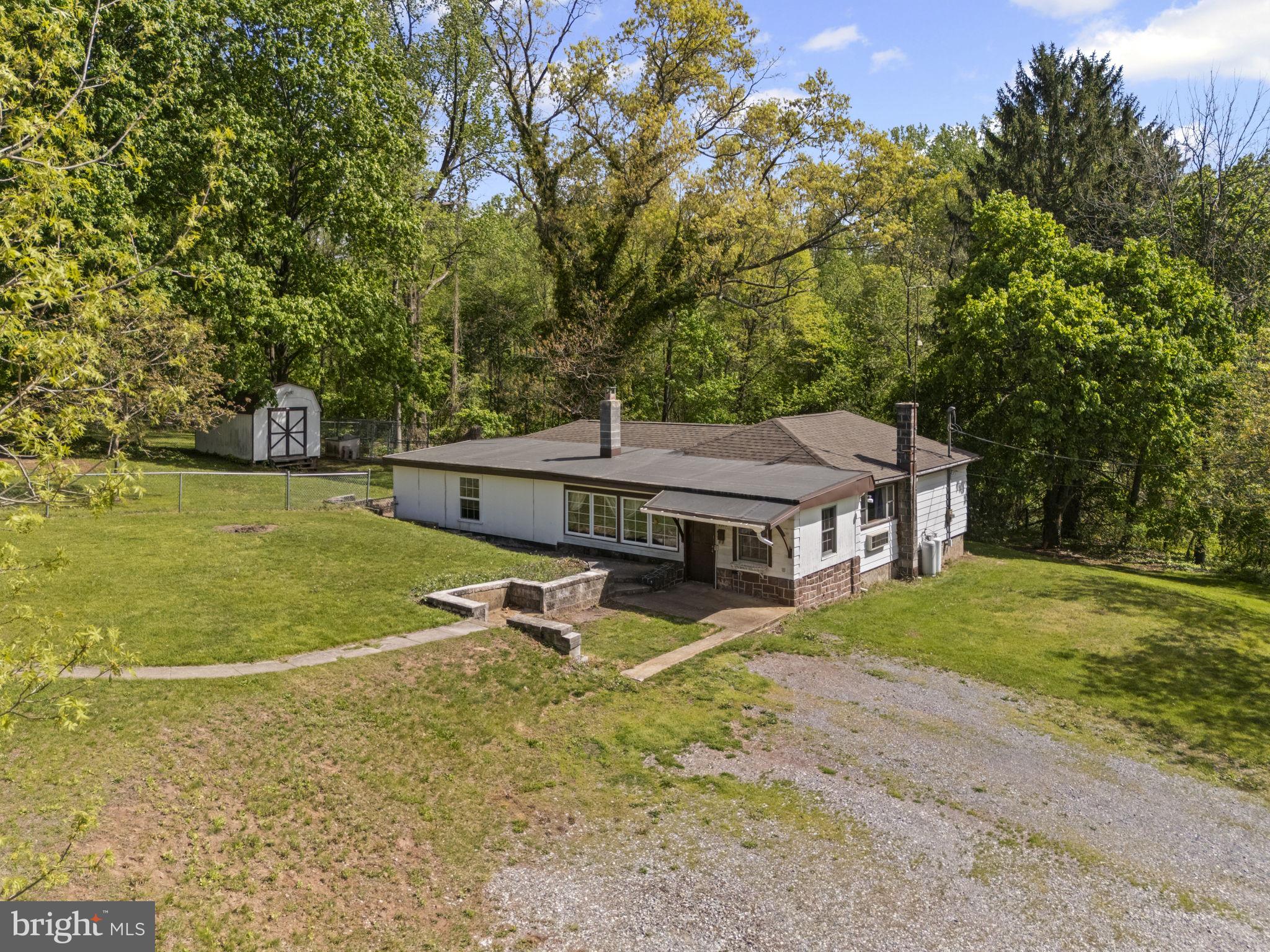 Cozy ranch-style home nestled on 3.23 acres, offering a peaceful setting and room to grow. Whether you're a homeowner looking to customize or an investor seeking opportunity, this property has much to offer. The home features several recent updates, including a new roof (2021), wall-mounted HVAC unit for heating and cooling in the living room (2024), gas range (2023), bathroom renovations (2020), 200-amp electric service, and newer windows in the family room (2024). Inside, you’ll find a mix of hardwood, LVP, and ceramic tile flooring throughout. In 2021, the owner enclosed a 12' x 24' room, adding approximately 288 sq ft of potential living space. This bonus area awaits your finishing touches and a heating solution to make it fully functional. Enjoy the outdoors from the 16' x 17' covered patio, perfect for relaxing and watching wildlife. The private rear yard includes a fenced area and a 6’fence surrounds a large  garden area ideal for growing your own vegetables or fruits and dog kennels with fencing, all of which convey with the property.  Property also features a spring house, a small brook and boasts a variety of fruit and nut trees, including English walnut, pecan, apple, pear, and hican, along with blueberry bushes, grapevines, and strawberry plants. Additional features include a 12' x 18' garage and a 16' x 10' shed, both with electric service. The home sits on a 1.88-acre parcel (Parcel ID: 39-000-OG-0029-00-0000) and includes two adjoining parcels: .96 acres (39-000-OG-0029-A0-00000) and .39 acres (39-000-OG-0029-B0-00000).Access is available via a paved shared driveway from Red Bank Rd as well as an additional entry point from Erney Rd. Zoning allows for chickens (permit required through Newberry Township).