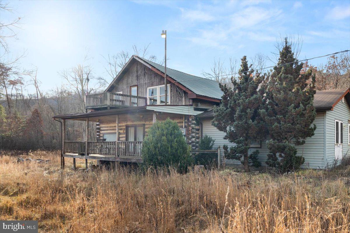 Looking for a log home in Hampshire County in a neighborhood with its own personal lake to enjoy fishing and swimming with family and friends? Come check out this 5 bedroom 2 1/2 bath home sitting on 5 acres that is just waiting for someone to come in and bring this beauty back to life and become your full-time residence or just a weekend getaway