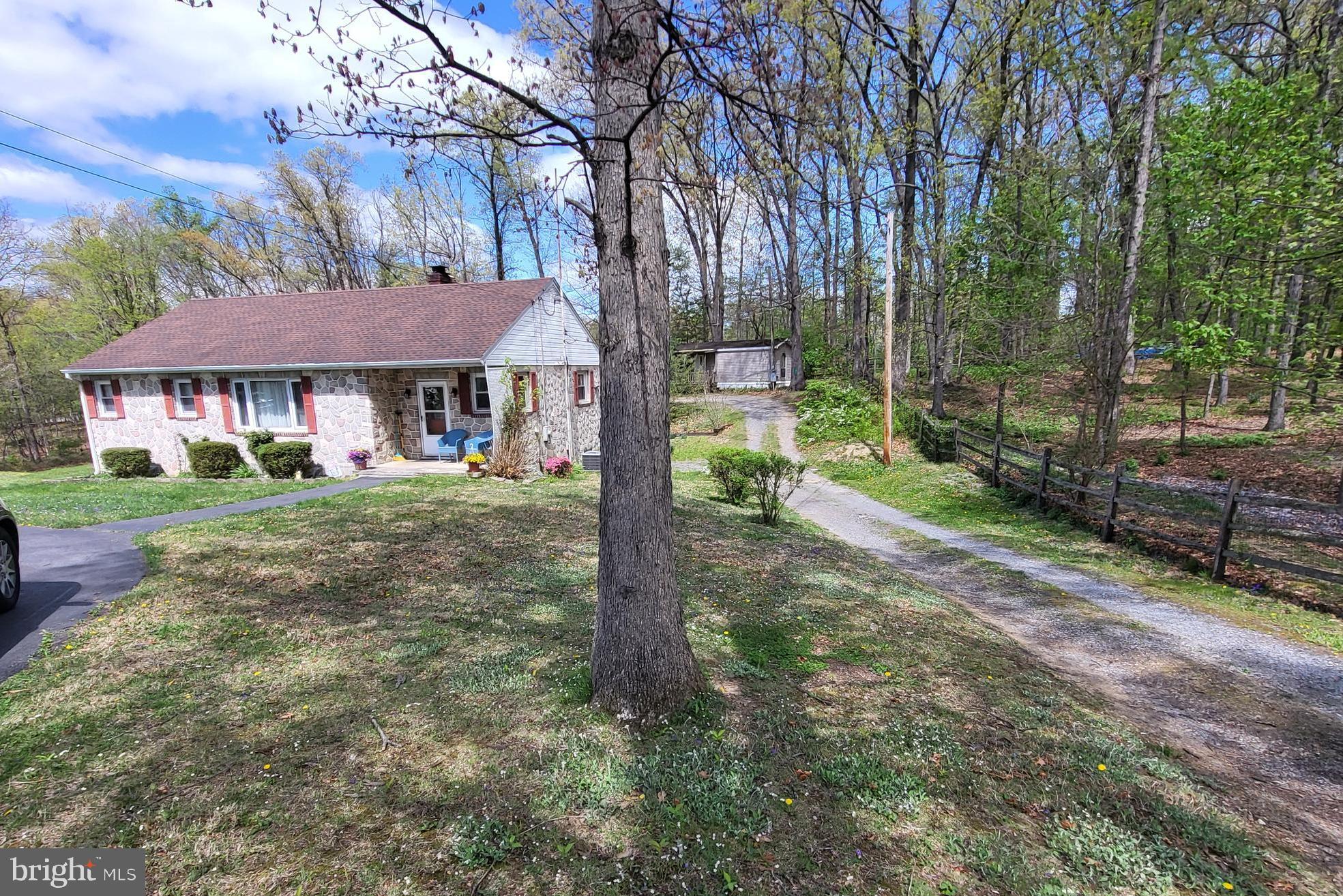 "Picturesque Setting"  Offering single family home w/rentable mobile home for extended family or income!  3 to 4 bedroom home has additional bath, bedroom & kitchenette in semi-finished basement (potential in-law suite?).  Wood floors and newer LVP in kitchen!  Room for everyone and their hobbies.  4 car garage space/ workshop & shed!    Public water & sewer.  Also, 1993 2 bedroom mobile home at rear of lot has its own septic.  This has been a nice arrangement w/family members- Now owner retiring.    All situated on a 1.4 acre country lot!