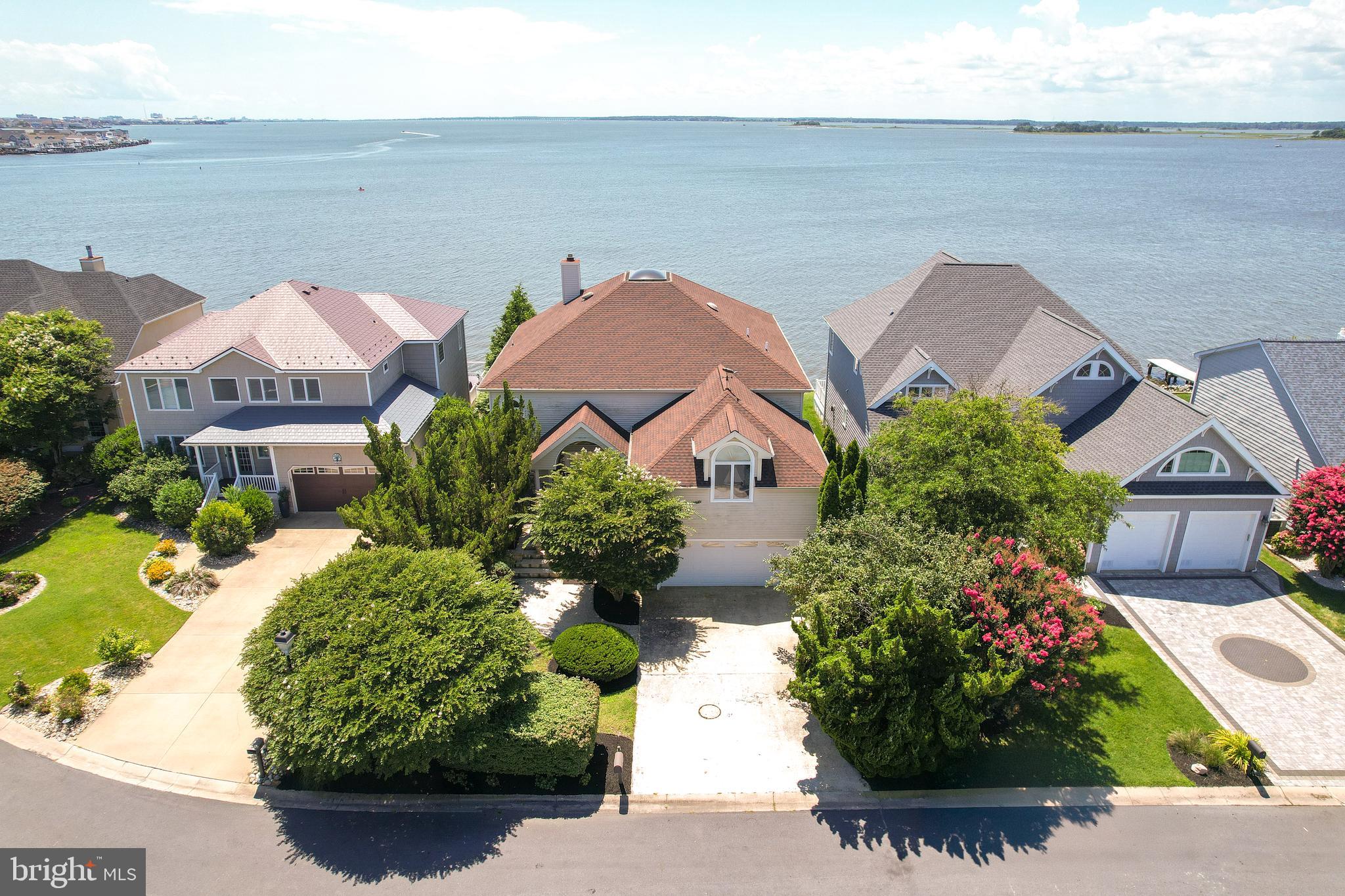 Rarely available and truly one-of-a-kind, 13525 Madison Avenue offers a premium bayside lifestyle in the exclusive, no-thru-traffic community of Nantucket Point. One of the original homes in the neighborhood, this 4-bedroom, 4.5-bath waterfront retreat has been lovingly maintained and thoughtfully updated for modern coastal living.
Set directly on the bay, the home boasts two highly coveted boat slips in the private Nantucket Point marina—an amenity that’s incredibly hard to come by. One slip is fully equipped for a sailboat, the other equipped for a boat. Enjoy breathtaking water views from the composite deck that extends to the bay, perfect for entertaining or catching sunset skies. This extension going to the bay is no longer available for homeowners and has been grandfather in with this home. Access water activities directly from the back yard, with a private dock ready to handle jet skis, kayaks and more.  A small fenced yard adds space for you pets to retreat too.
Spanning over 3,600 sq ft, this home is an entertainer’s dream with an open-concept layout, soaring high vaulted ceilings, and breathtaking bay views through dramatic floor-to-ceiling windows. The heart of the home features a one-of-a-kind Ficus tree stretching two stories tall up through the 2nd story mezzanine, providing quality air with its own indoor ecosystem.
The chef’s kitchen is equipped with a large island, stainless steel appliances, a double oven and double microwaves, extended counter seating, and abundant cabinet space. Large dining area off of the kitchen provides immediate access to the back deck. Laundry room also offers extra pantry space, wash sink and outside access.  The great room features a wood burning fireplace, cozy carpet, access to the deck and floor to ceiling Bay views.  Each of the 4 spacious bedrooms includes its own private full bath, including a luxurious second-floor primary suite with a private deck overlooking the bay. This primary suites bath not only has a jacuzzi tub, double vanity, and glass walk-in shower but a bidet as well. All closet spaces are generous, however the primary suite boasts a walk in closet. One bedroom can be found on the main level providing easy access for guests and/or family who may have trouble dealing with the stairs. Additional features include an impressive  foyer that greets you with high ceilings and an additional sitting area,  ceramic tile flooring through-out,  a two-car garage, mature landscaping creating a more private oasis, and front porch.  This home is also already equipped with hurricane shutters, reverse osmosis and water conditioning system. 
Enjoy the  community amenities, including pool privileges with their low hoa fees.  Bonus- you can see The fireworks from Northside Park, Seacret, downtown OC, and Ocean Pines all from the deck; it’s a spectacular Fourth of July celebration! 
This home has been a family retreat for years, as well as an established vacation rental with excellent income history and providing the highest rental ratings/testimonials.  Located just minutes from Ocean City’s iconic beaches, entertainment, and dining, with easy access to the Delaware beaches as well, this home truly has it all—luxury, lifestyle, and investment potential. Don't hesitate to make this one of kind, hard to find Nantucket Point, water front property your home sweet home!