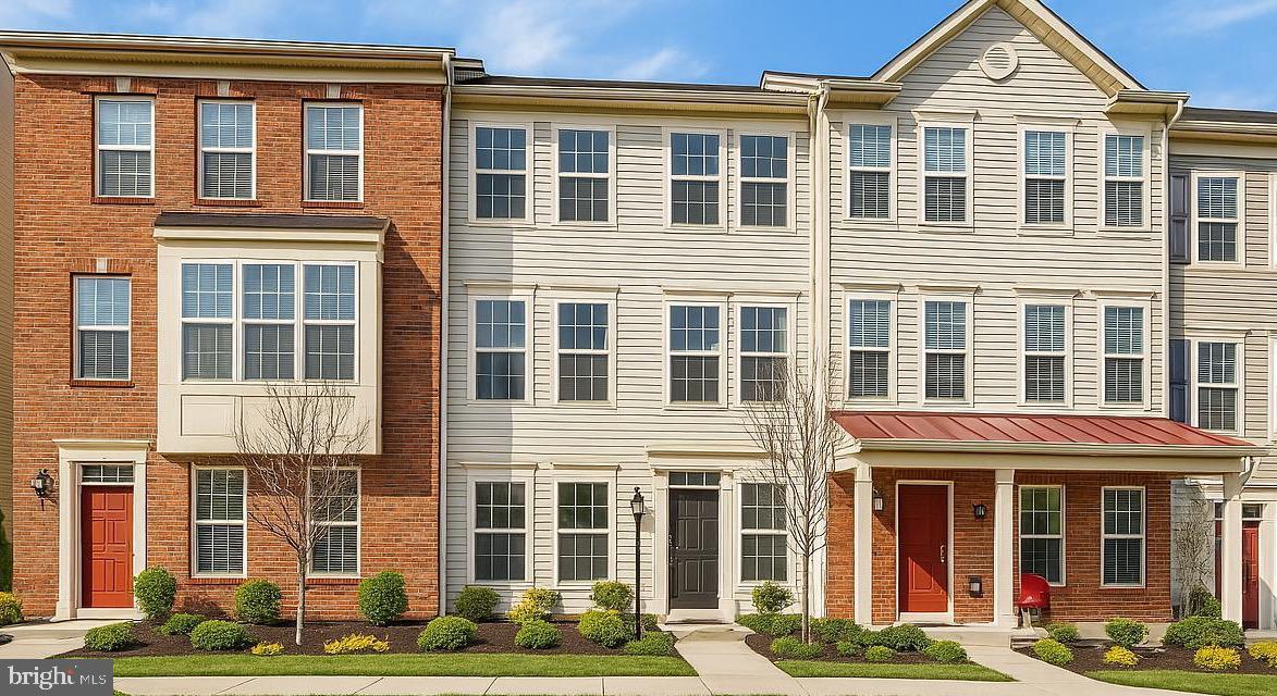 Welcome to 7209 Greenfitch Way, a beautifully appointed interior townhome nestled in the sought-after Oxford Square community of Hanover, MD. This refined residence offers the perfect blend of timeless elegance, modern convenience, and thoughtful design. The exterior showcases low-maintenance vinyl siding framed by meticulously landscaped grounds, offering an inviting first impression. Inside, a sunlit foyer welcomes you with gleaming engineered hardwood floors that flow into a spacious recreation room featuring a striking accent wall and a full en-suite bathroom with a walk-in shower. This flexible space easily doubles as a guest suite or entry-level bedroom. Additional features on this level include tailored window treatments, a custom-built mudroom with ample storage, and direct access to the oversized two-car garage. The main living level is a true centerpiece, where freshly painted walls, detailed crown molding, and rich hardwood floors create a sophisticated ambiance. The gourmet kitchen is outfitted with 42” espresso cabinetry, granite countertops, a large island with bar seating, stainless steel appliances including a gas range, built-in microwave, and refrigerator, and a cozy coffee nook. Step outside to a private TREX deck—perfect for morning coffee or evening entertaining. A charming butler’s pantry leads to an expansive walk-in pantry, while a stylish powder room completes this level. Upstairs, the private quarters include a serene owner’s suite with plush carpeting, elegant window treatments, a generous walk-in closet, and a spa-inspired en-suite bath featuring dual granite vanities, a glass-enclosed walk-in shower, and a private water closet. Two additional bedrooms, a full bathroom with tiled tub/shower, a linen closet, and a full-size laundry area complete the upper level with ease and comfort. This home was built with energy efficiency at its core, boasting a 92% efficient gas heating system, high-efficiency HVAC, Tyvek HomeWrap, dual-pane Low-E windows, premium insulation, sealed air barrier and ductwork, a fully insulated steel garage door, newly replaced water heater, brand new dishwasher and durable 20-year architectural shingles ensuring year-round comfort and cost savings. Perfectly located for effortless commuting, this home is just minutes from major highways like 295–Baltimore-Washington Parkway & Route-100, with quick access to both Baltimore, Washington, D.C., Arundel Mills, BWI Airport and so much more. Residents enjoy the convenience of a private community shuttle to the Dorsey MARC Station and are zoned for some of Howard County’s top-rated schools with the Elementary & Middle School in the community. The Oxford Square community further elevates the lifestyle with resort-style amenities including a sparkling swimming pool, state-of-the-art fitness center, basketball courts, playfields, playgrounds and lush open green spaces. Experience luxury, comfort, and community all in one extraordinary home. Don’t miss this rare opportunity—schedule your private showing today.