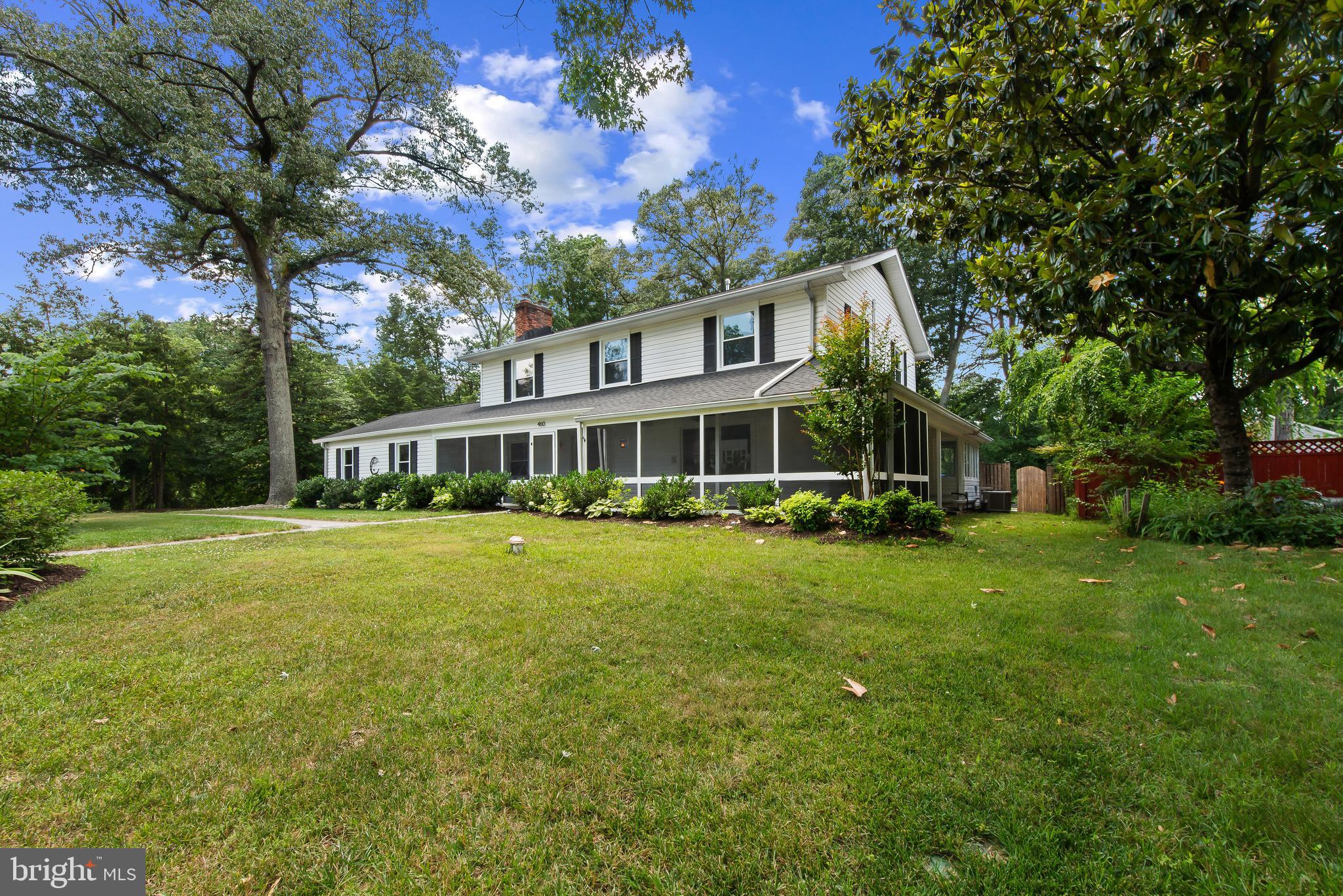 Severna Park home featuring a spacious, versatile floor plan enhanced by numerous updates and improvements.  Multi Generation capability as there is a separate apartment in the basement. The current owners have thoughtfully reimagined the rear porch, transforming it into a bright and inviting living space with vaulted ceilings, expansive windows, and a natural connection to the main living area.

The wrap-around front porch provides a welcoming entrance, while the interior offers a blend of comfortable everyday living and spaces well-suited for entertaining. Formal living and dining rooms are accented by traditional chair rail detailing and offer flexibility for gatherings both large and small.

The family room serves as a comfortable gathering space, complete with new LVP flooring, built-in bookcases, and a wood-burning fireplace. The kitchen features recessed lighting, white cabinetry, modern appliances, and an adjoining breakfast area.

Upstairs, the primary suite includes two walk-in closets and a private bath with separate vanities and a glass-enclosed shower. Three additional well-proportioned bedrooms, a full bath, and a conveniently located laundry room complete the upper level. All new carpeting on the upper level.

The finished lower level offers excellent flexibility with a private in-law or guest suite that includes a second kitchen, living and dining areas, two bedrooms, a full bath, and a separate laundry room.

Outside, the fenced rear yard provides ample space for recreation and entertaining, complemented by attractive hardscaping, a patio, and a fire pit gathering area. Updated HVAC systems contribute to the home's overall comfort and efficiency.

Recent improvements include the finished rear porch conversion, HVAC updates, rear yard fencing, hardscape patio and fire pit, kitchen and living room flooring, landscaping, interior paint, and well pump.
