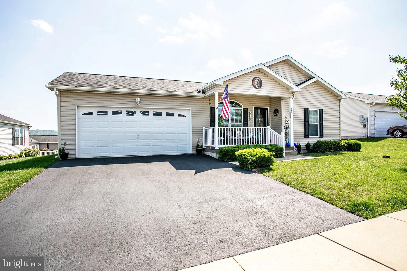Very well cared for home in Douglas Village, one of the largest models (Holly1) in the community. This lovely community is conveniently located to routes 422, 363 and 100 and features a club house with an exercise room and an outdoor pool.  Enter this home from the covered front porch and step into the living room which is separated from the dining area with a knee wall and half columns.  The open kitchen, dining area and den are tied together with the living room by wide width engineered wood floors. The kitchen has a breakfast island with stools, lots of cabinet space with additional cabinets in the dining area, recessed lighting and flat-top stove with microwave vented hood.  The dining area has sliding doors out to a large deck rebuilt in 2024 with vinyl rails and decking. There is a convenient laundry room with a washer, dryer and utility wash tub. The main bedroom is situated away from the 2 guest bedrooms and features its own bath with a double vanity and walk in shower. There is also a walk in closet. The other 2 bedrooms have wood floors and ample closet space and have a hall bath in between them. The bath features a tub with surround. There are ceiling fans in all of the bedrooms as well as the living room and den. Also off the dining area is the door to the 2-car attached garage which is front entry and includes an electric opener. The exterior is low maintenance siding. There is a 1-year home warranty included with the purchase. This community is not a homeowner's association but does have rules and regulations and the ground rent includes mowing, weed wacking, snow plowing of the roads and public walkways, weekly trash removal, access to the club house (with a library, gym and community room) and the pool, The sewer and water are billed through Douglas Village.
