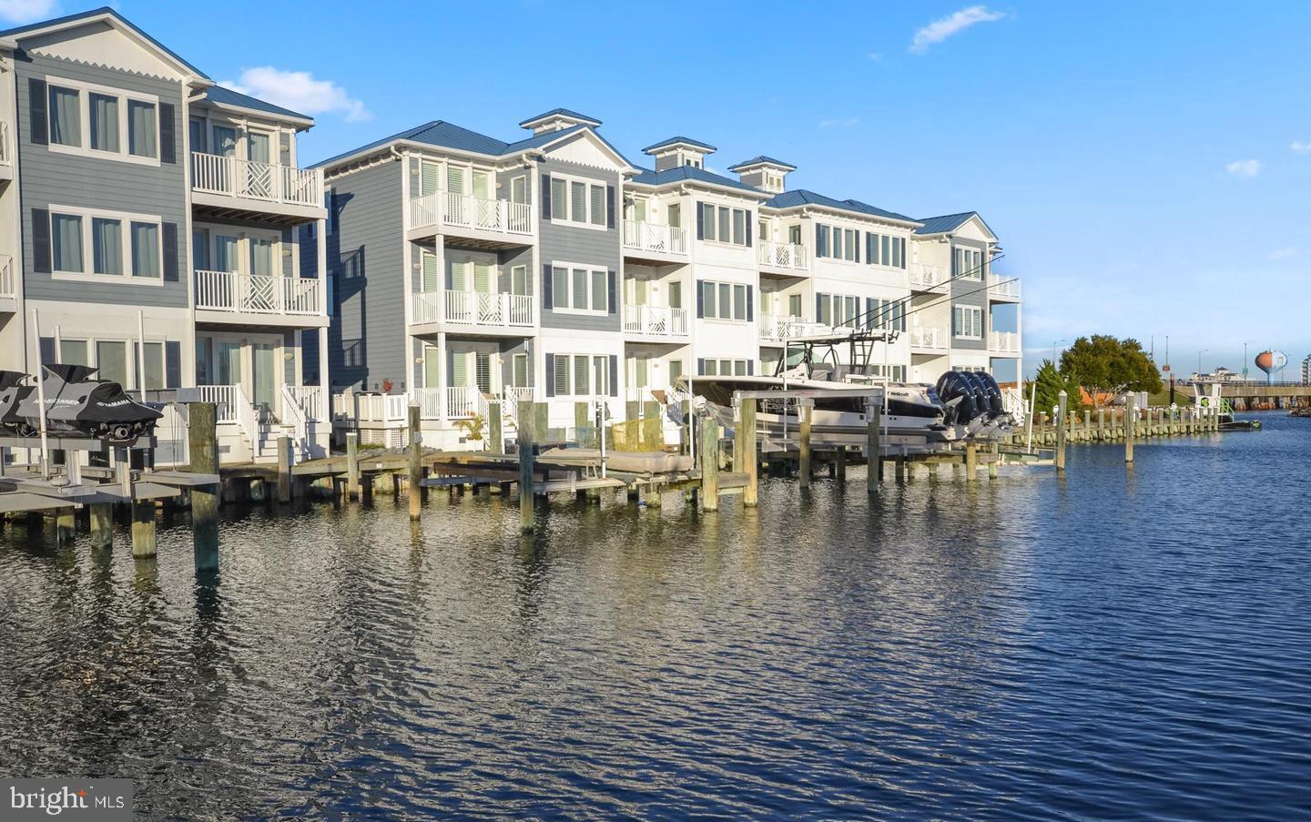 Luxurious custom coastal home with a 38ft boat slip, boat lift 7,000 lbs, beautiful views of the Marina. This unit was custom designed for original owner. This Stunning townhouse makes a perfect second home or primary residence. The first level boosts a second kitchen, family room, laundry, and bed and full bath for in-laws suite, or captain's quarters. This level leads out to a deck and down to the dock and boat. The second level boosts Primary suite with deck access with primary bath, laundry as well, guest bedroom and bath. Third level has Kitchen, Family Room, Dining, Gourmet Kitchen, Guest Room and Full bath. Home features: boat slip, custom glass door elevator, hardwood floors, newer HVAC 3rd floor, granite countertops, stainless steel appliances, custom window shutters, blinds, and window treatments, breakfast bar, decks on each level, great location to fishing center, Mickey Finns Restaurant, public transportation, perfect to view fireworks, easy access to the bay, community pool, epoxy coating on garage floor. 
3-level layout with glass-door elevator
In-law suite (first level) with kitchen, family room, and deck access
Primary suite (second level) with private deck and luxury bath
Gourmet kitchen (third level) with breakfast bar, stainless steel appliances, and granite counters
Community pool and prime waterfront location near dining/boating amenities
Additional highlights include hardwood floors, epoxy-coated garage, and newer HVAC system. Positioned near Mickey Finns Restaurant and public transportation, this home combines luxury with coastal convenience.  This is a stunning community, great location, and turn-key.  Schedule your showing today.