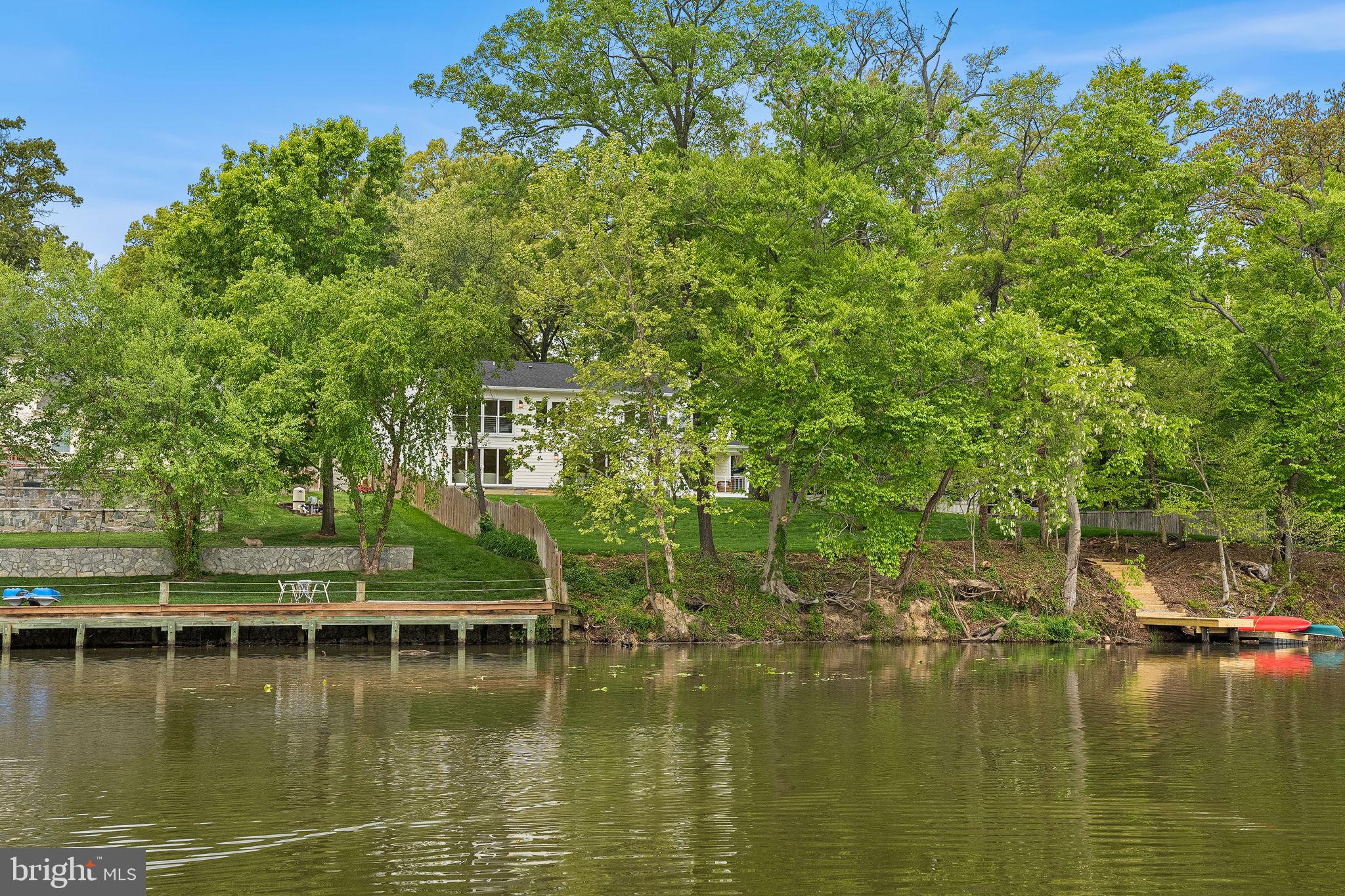 Set along the tranquil shoreline just off the scenic George Washington Memorial Parkway, this newly constructed waterfront retreat offers a rare opportunity to embrace a relaxed, resort-like lifestyle—only 15 miles from Washington, DC.

Positioned on a .60-acre lot with over 150 feet of expansive water frontage, the 5100 Sq ft home captures sweeping, peaceful views that instantly shift the pace of daily life. With direct access to the Potomac River, mornings begin with calm reflections on the water, and evenings unwind with breathtaking sunsets—all just moments from the energy of the nation’s capital.

Spanning nearly 5,100 square feet, the residence is thoughtfully designed with BOTH a main level and upper level primary suite.  Six spacious bedrooms each with water views, ensuite baths, and custom closets, creating private retreats throughout the home. Wide-plank, sand-in-place white oak flooring and refined finishes add warmth.

At the center of the home, the chefs kitchen features custom cabinetry, GE Profile stainless steel appliances, a four-burner plus grill dual-fuel range, and a generous walk-in pantry. The adjoining family room, anchored by a gas fireplace, flows effortlessly to 577 sq ft  deck with sleek wire railing—an ideal place to relax, entertain, or simply take in the stillness. The dining area extends naturally to outdoor living spaces and adjacent to the 140 sq ft  covered porch offering indoor-outdoor entertainment.  The oversized two-car garage  walks into a well-appointed mudroom.

Upstairs, a spectacular second primary suite spans over 1,200 square feet, offering a true private sanctuary. Dual custom walk-in closets and a spa-inspired bath with marble and porcelain finishes, heated floors, soaking tub, and designer lighting create a luxurious, restorative space. A large laundry room with built-in cabinetry, sink, and LG front-load washer and dryer adds everyday convenience. Three additional bedrooms with ensuite baths all with water views.

The lower level  is walk out and provides additional flexibility with a spacious recreation room, kitchenette, and a sixth bedroom or fitness space with a full bath—ideal for guests or extended stays.

Just steps away, a community boat ramp, picnic area, and waterfront deck invite easy, spontaneous enjoyment of the river. The surrounding area offers scenic trails and access to George Washington's Mount Vernon, perfect for walking, biking, and soaking in the natural beauty of the region.

This home delivers more than just luxury—it offers a lifestyle defined by calm, connection, and effortless waterfront living, all within close reach of the city.