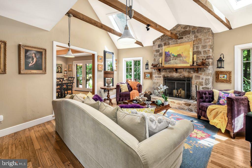 It’s love at first sight when you turn down the gravel driveway, cross the wooden bridge over Rapp creek, and peek around the corner at a fairy tale come to life. Set on 7.5 acres and complete with its own stone turret, Overbrook Manor has the feel of a cozy country cottage, yet is spacious enough to host family and friends year round.
     Terraced gardens embrace the front walkway, leading to that incredible turret which serves as the foyer. Step through etched glass doors into a sunken living room, with high ceiling and stone fireplace. The kitchen is a delight, featuring an exposed brick wall, granite countertops and stainless appliances, with a breakfast area, family room, and formal dining room just steps away. 
Two bedrooms are on this level, including the primary suite with large walk-in closet and luxurious bathroom featuring a laundry closet and plenty of storage. The curved staircase leads to three additional bedrooms and a full bath. Extra storage space can be found in the lower level, which also walks out to the side yard.  A recently remodeled guest cottage with private entrance includes a fully appointed kitchen, bedroom and full bath.
     The expansive rear deck is shaded by tall trees, while the sunny front patio is a charming spot for morning coffee or afternoon drinks. Other outdoor amenities include a 2-car detached garage with exercise room and workshop, chicken coop, gazebo and more. A storybook home far from the hustle and bustle of everyday life, yet close to needed amenities.