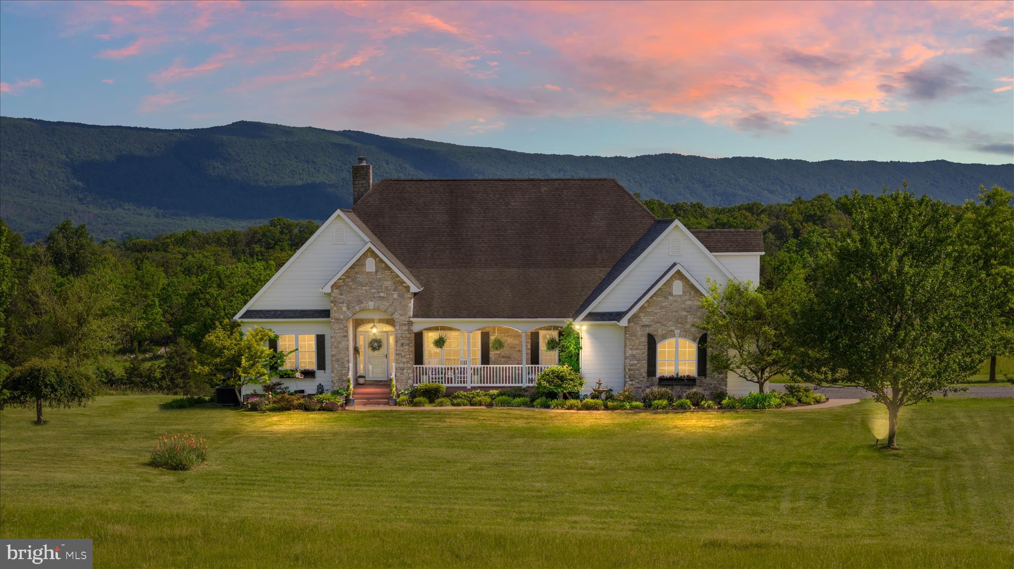 Experience the perfect blend of luxury, privacy, and breathtaking natural beauty on this exceptional 23.5-acre estate.  Custom built by a respected local builder, this remarkable property offers nearly 5,000 finished square feet of thoughtfully designed living space, showcasing quality craftsmanship and custom finishes throughout.  The striking exterior combines timeless brick, stone, and fiber cement (Hardie Plank) siding, creating impressive curb appeal and lasting durability.  Inside, the gourmet kitchen serves as the heart of the home, featuring high-end finishes, abundant workspace, and seamless flow into inviting gathering areas accented by custom built-in cabinetry and stunning views from nearly every window.  With 4 spacious bedrooms and 4.5 baths, this home offers comfort and flexibility for family living and entertaining alike.  The finished lower level expands the living space with a billiard room, exercise room, extensive storage areas, and a unique pet suite complete with a fenced holding area and dedicated bathing room—perfect for animal lovers.  Step outside and immerse yourself in some of the area's most spectacular panoramic, pastoral, and mountain views.  Multiple outdoor living spaces, including a screened porch and expansive composite decking, provide the ideal setting for morning coffee, sunset gatherings, or simply enjoying the peaceful surroundings.    Equestrians and hobbyists will appreciate the impressive 5-stall horse stable featuring its own well and electric service, along with a substantial 20' x 40' metal garage building offering endless possibilities for equipment, vehicles, or workshop space.  Ideally located with convenient access to I-81 and I-66, this extraordinary property delivers the rare combination of rural tranquility and commuter convenience.  Additional acreage may also be available for purchase, offering even greater opportunity to expand your vision.  Properties of this caliber and setting are rarely available.  Schedule your private showing today and discover the lifestyle you've been dreaming of.