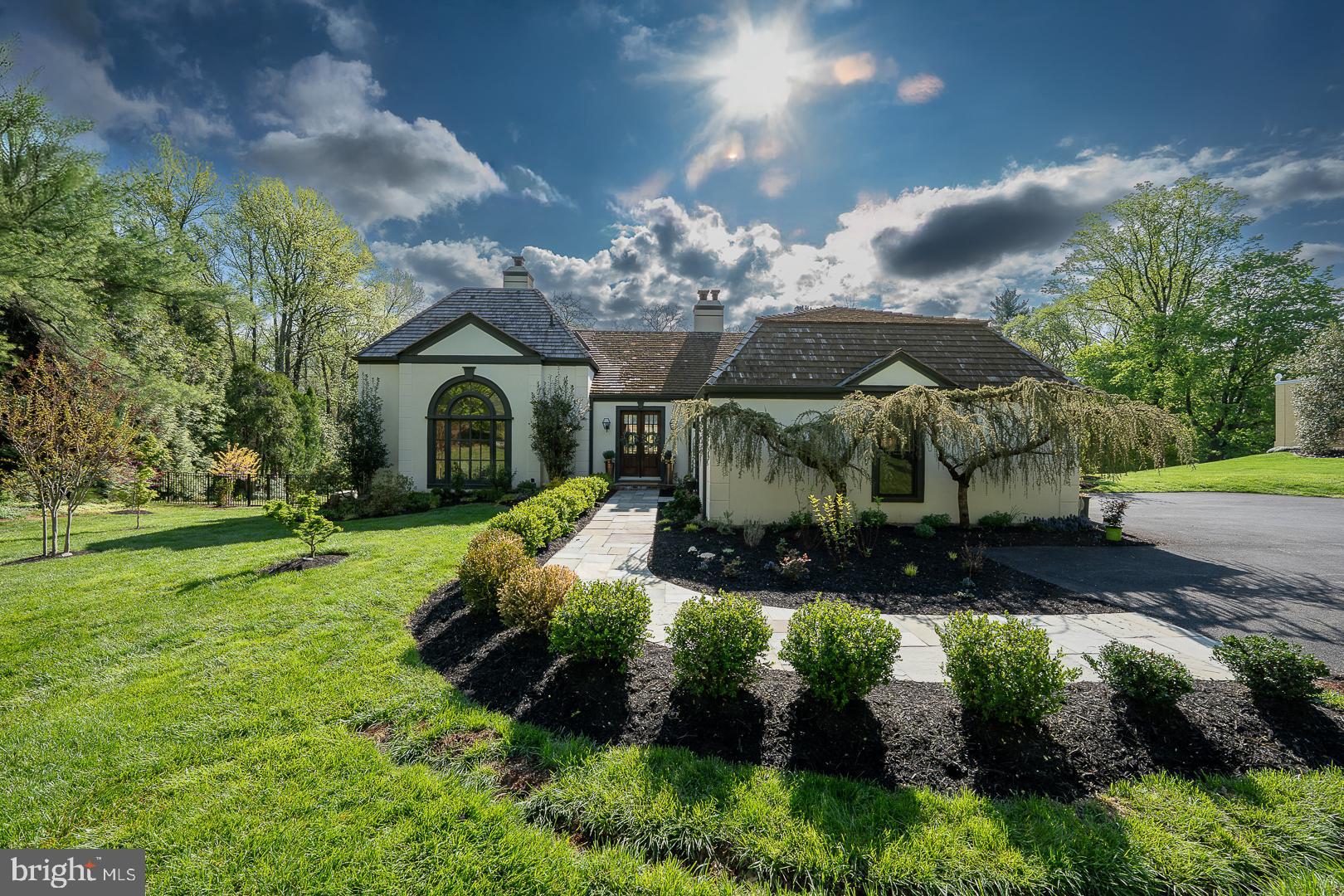 This is the home you’ve been waiting for—completely reconfigured and redesigned, inside and out, to offer first-level living at its absolute prime. Set on over an acre of level ground on a quiet street in coveted Northside Bryn Mawr this property exudes privacy, yet remains minutes from the vibrant heart of downtown Bryn Mawr with easy access to the iconic Bryn Mawr Film Institute, boutique shopping, fine dining, parks and all the premier amenities the Main Line has to offer. Step into a sunlit foyer and notice the breathtaking living room to your left featuring a dramatic barreled ceiling, bespoke built-in cabinetry, and a sophisticated wet bar. The heart of the home is a chef’s custom kitchen, anchored by a central island topped with quartz counters and seating for two. This culinary masterpiece is fully equipped with professional-grade Viking appliances, including a high-performance warming drawer, a signature French door oven, and a classic farmhouse sink. Transition effortlessly to outdoor entertaining from the kitchen onto a premium Trex deck, complete with a dedicated gas line for your grill—the perfect vantage point to enjoy your sprawling, level, private backyard. A cozy family room with fireplace is open to the kitchen for easy socializing with family and guests. The seamless flow continues through an arched doorway into the spacious dining room, which boasts elegant custom millwork. The pinnacle of main-level living is in the meticulously reconfigured primary suite, designed as a private sanctuary with seamless indoor-outdoor flow. Elegant doors lead directly to a custom-built patio—perfect for morning coffee or a quiet evening under the stars. Step onto radiant heated floors and relax in the state-of-the-art air bubble tub or enjoy the restorative benefits of a custom steam shower. Walk into the spacious closet featuring high-end organization systems and the innovative LG Styler Steam Closet, which uses TrueSteam technology to refresh, sanitize, and de-wrinkle your finest garments between professional cleanings. The laundry room is conveniently located to be accessible from the primary bedroom and from the mudroom. The generous layout continues upstairs, where you will find three additional bedrooms and a beautifully appointed full bath featuring a modern walk-in shower. For even more versatility, the lower level is completely finished and walks out to the rear yard (complete with a dog run) and offers an entertainment space, full bathroom and a private fifth bedroom, perfect space for a guest suite, home gym, or media room. Plus two car garage, an EV charger, Generac generator, new windows throughout, new stucco, new doors, Smart home lighting, custom window treatments- all in the Lower Merion School District (Gladwyne Elementary and Black Rock Middle School). From the designer finishes to the serene, park-like setting in a prime Main Line location this home is a total reimagining of sophisticated living at its finest and ready to simply move in.