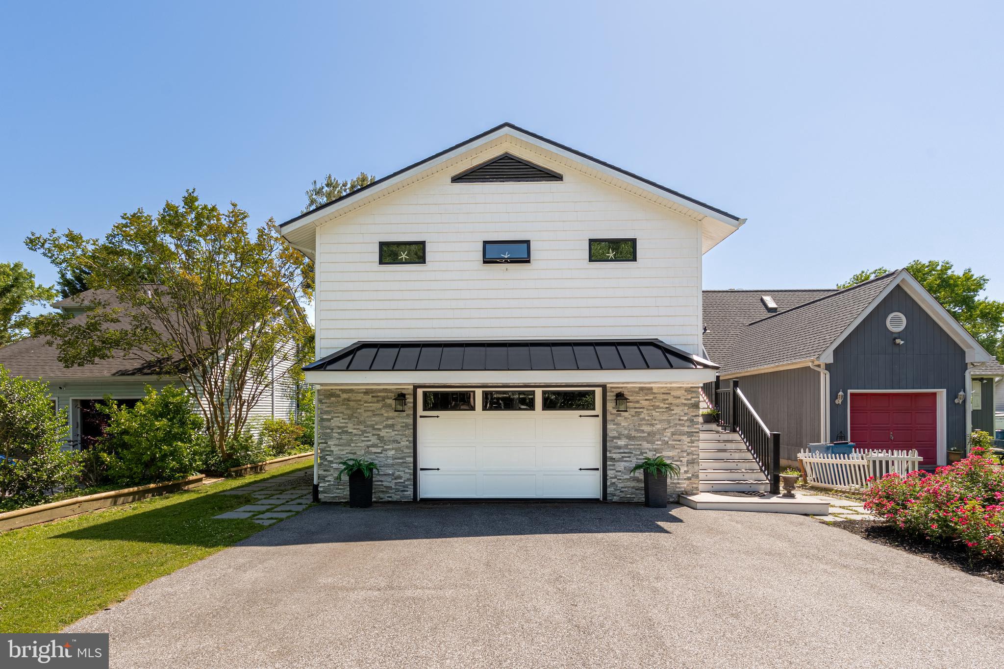 Nestled along the water in Ocean Pines, 44 Boston Drive is a beautifully renovated waterfront retreat offering the perfect blend of luxury, comfort, and outdoor living. Extensively remodeled in 2019, this stunning home was thoughtfully redesigned with raised ceilings, an open-concept floor plan, new siding and windows, and upscale finishes throughout. Step inside and immediately appreciate the light-filled great room featuring luxury vinyl plank flooring, a striking stone electric fireplace with space for a large-screen TV, and a wall of sliders that frame peaceful water views. The gourmet kitchen is truly the centerpiece of the home, boasting upgraded appliances, a large center island with granite countertops and dramatic waterfall edges, plus a convenient pantry for extra storage. This home offers 2 spacious bedrooms and 2.5 beautifully updated baths, each showcasing custom tile work, vessel sink, designer paint selections, and elegant finishes. The primary suite provides a relaxing retreat with a gorgeous private bath and generous closet space. Outdoor living is where this property truly shines. Step through the expansive sliders onto the huge wraparound deck with sleek glass panels designed to maximize the breathtaking water views and surrounding nature. A newer pier and dock make waterfront living effortless, whether you enjoy boating, kayaking, or simply soaking in the scenery. One of the most unique features of this property is the oversized backyard — a rare find in this section of Ocean Pines — offering endless possibilities for entertaining, family gatherings, cookouts, and lively cornhole tournaments. Beneath the deck, you’ll find an additional covered outdoor living area perfect for creating your own private patio retreat, complete with your own hot tub to enjoy year-round. Additional highlights include mature landscaping and a spacious 2-car garage ideal for storage of all your beach and boating essentials. This exceptional waterfront home has been meticulously updated and designed for easy coastal living. A must-see property that truly delivers the Ocean Pines lifestyle — you won’t be disappointed.