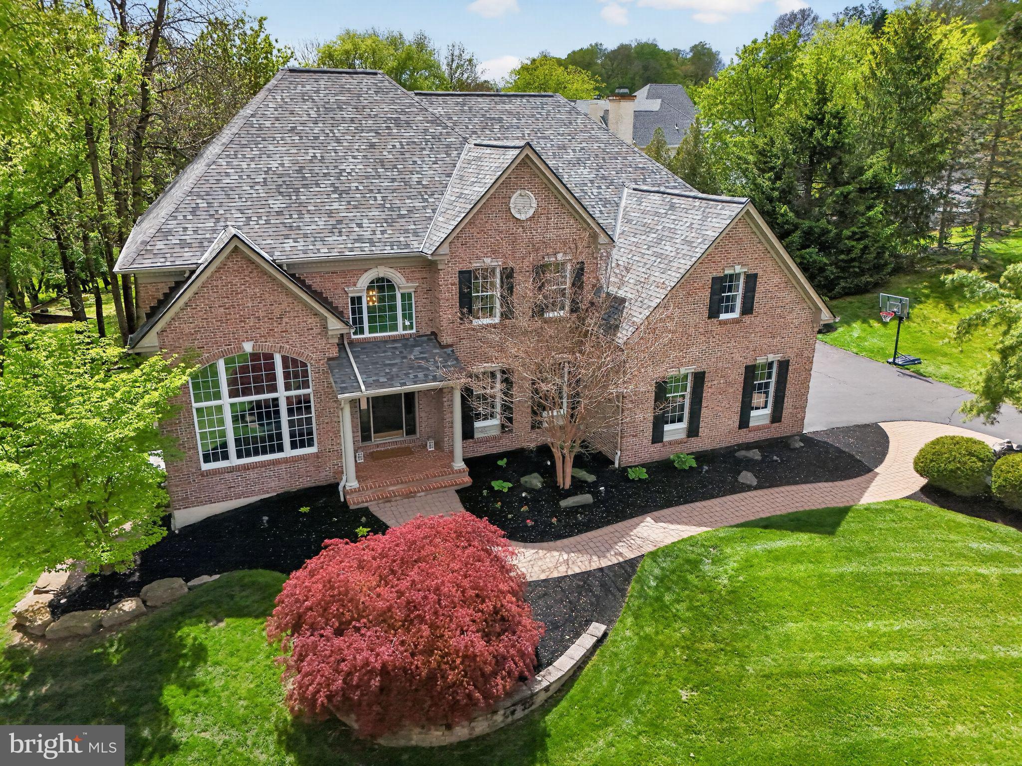 Set on 1.14 wooded acres in Upper Holland, 1860 Powderhorn Ct offers 4 bedrooms, 3.5 baths and approximately 4,565 square feet of above ground finished living space.  This home is tucked into a small enclave of homes in a private cul-de-sac setting with elevated treetop views from nearly every room. Positioned back from the street on a gently raised lot, this home delivers a rare combination of privacy, natural light, generous interior space, and thoughtful updates.
A two-story foyer introduces the home with an open, impressive feel and leads into a dramatic two-story living room with substantial picture windows. Refinished hardwood floors in a warm special walnut finish extend through most of the first floor, creating a rich and cohesive look. The main level also includes a formal dining room that can accommodate an oversized table, a dedicated office off the foyer, a powder room, and a laundry room with a newer washer and dryer.
The kitchen has been tastefully updated with new quartz countertops and a coordinating artisan tile backsplash. There is  an abundance of warm brown cabinetry, a walk-in pantry, and newer stainless steel appliances. The kitchen, breakfast area, and family room flow together in an open layout that supports both daily living and effortless entertaining. Adjacent to the family room, the sunroom is one of the home’s most memorable spaces, featuring walls of windows, tile flooring, abundant natural light, and beautiful wooded views. From the sunroom and kitchen, access the beautiful mahogany deck, where the elevated position of the home creates a peaceful treetop feel.
Upstairs, the luxurious primary suite offers a dramatic double door entry to this retreat. It includes a comfortable sitting room, double walk-in closets, an ensuite bath with a vaulted ceiling, double vanity and private toilet closet. Three additional spacious and bright bedrooms are also located on the second level, including one ensuite bedroom. A dual staircase from both the foyer and kitchen adds function and convenience.
The walkout basement provides excellent potential for future finished living space and opens via sliding doors to a hardscaped patio overlooking your private sanctuary. Relax here or meander up to the deck and listen to the birds sing or read a book.  Outdoor features include a mahogany deck, a covered front entry area, hardscaped walkway, refreshed landscaping, brick front facade, and premium beaded siding.
Major improvements include a new roof in 2023 and both HVAC units were replaced in 2025. Most light fixtures have been updated with a modern aesthetic, and the home is painted in neutral tones throughout. There is a water conditioning system that consists of a softener, carbon filter and additional filtration for the entire home. A three-car garage with  one smart opener, adds everyday convenience.
This Council Rock location offers easy access to Core Creek Park, Tyler State Park, Newtown, St. Mary Medical Center, The George School, Route 1, I-295, and SEPTA rail. With its private wooded setting, expansive layout, thoughtful updates, and treetop views from nearly every room, Powderhorn Ct offers a rare opportunity to enjoy space, comfort, and everyday convenience in one of Upper Holland’s most desirable residential settings.