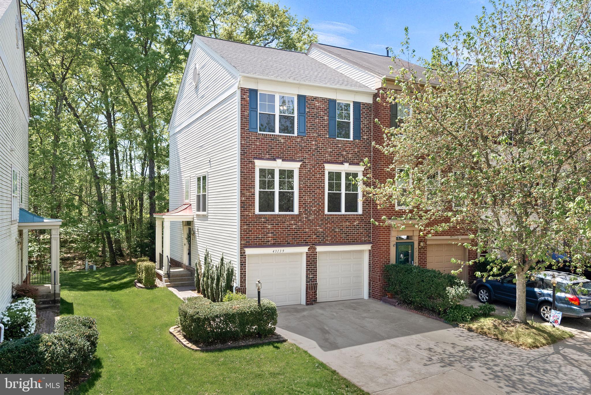 Nestled up against a backdrop of mature trees, this three-level end unit townhouse offers a perfect blend of comfort, convenience, and modern living. Located in the highly sought-after Broadlands neighborhood, this residence is ready to welcome its new lucky owner. Upon entering, you'll be greeted by  a welcoming entry-level rec room, with built in book cases and access to the beautiful patio, as well as a half bath. The main level features spacious, sunlit living spaces.  From the eat-in kitchen, with its oversized island and newer appliances, you can step out onto a large deck that overlooks open space and serene trees, providing a perfect spot for morning coffee or evening gatherings. Upstairs, discover two generously sized bedrooms, each boasting oversized closets and en suite private bathrooms. The upgraded primary bath has a new seamless shower w/glass enclosure and extra storage. The upper-level also houses the laundry area, adding ease to your daily routine. With a two car garage, two driveway spaces, and nearby guest parking, you should find parking a breeze. This home is freshly painted and well- maintained, with significant updates for peace of mind - All windows and sliding doors replaced (2022), Dishwasher (2023), Washer/dryer (2021),  Stove & Microwave (2021), Furnace (2018). Zoned for Hillside Elementary, Eagle Ridge Middle, and Briar Woods High Schools. The home is also within walking distance to one of three community pools and playgrounds. Broadlands offers a host of wonderful amenities, including three pools, extensive trails, playgrounds, and courts for tennis, pickleball, and basketball. Conveniently located just minutes from the Ashburn Metro Station, shopping, dining, and major commuter routes, this townhouse offers the perfect blend of suburban tranquility and convenience. Welcome Home!
