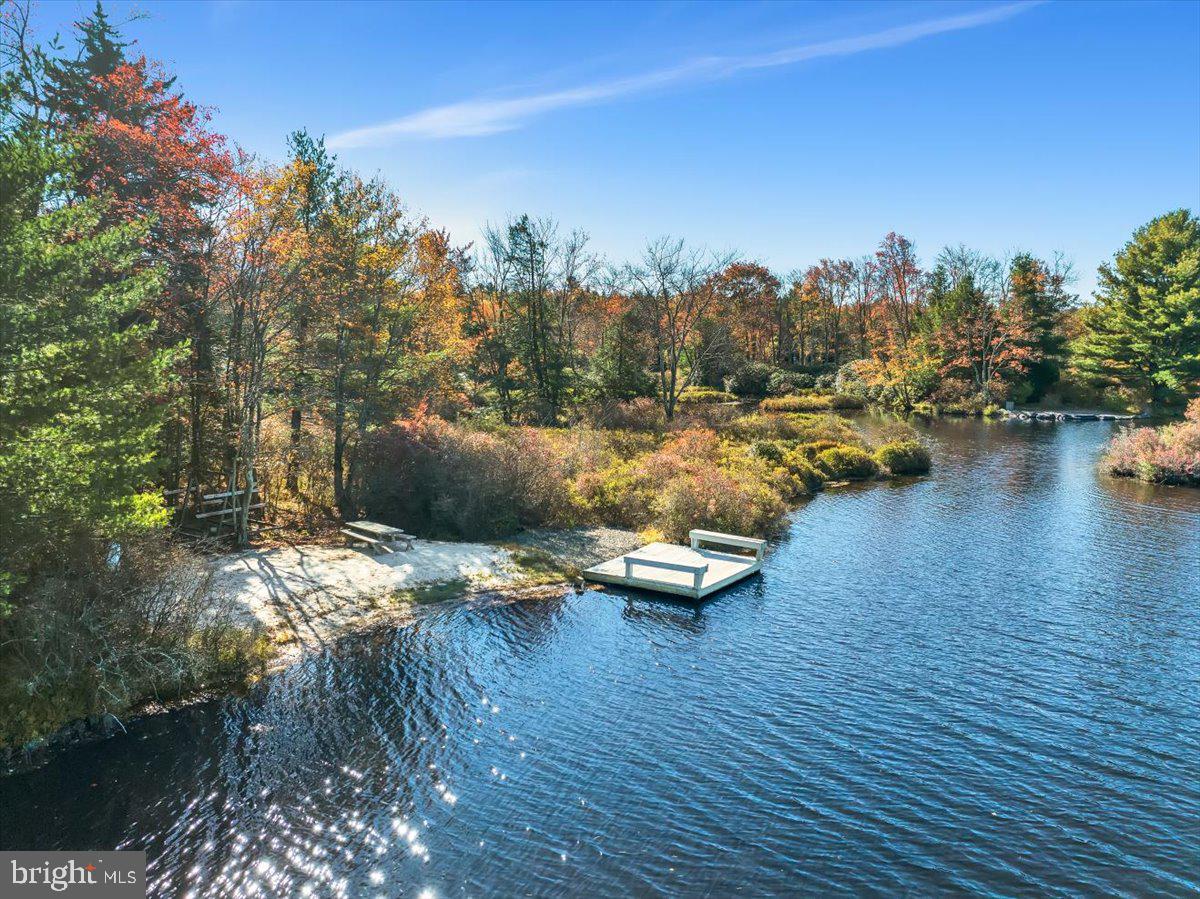 LAKEFRONT!!! This Lake Naomi waterfront home is nestled in the heart of nature's tranquility. This stunning 4-bedroom, 3.5-bath lakefront retreat invites you to indulge in a lifestyle of leisure and refined luxury. Boasting its own PRIVATE BEACH and a charming wooded path that winds gently to the water's edge, this property offers an unparalleled lakefront experience. The home features a stone-faced wood-burning fireplace, skylights, a game room/family room with a hot tub, recessed lighting, central air, and upgraded baths for added comfort and elegance.  Additionally, Lake Naomi Club membership is available, granting access to the exclusive amenities of the only 5-star Platinum Club Community in the Northeast. Enjoy top-tier resort facilities, including boating, swimming, golf, tennis, and resort-style pools, one of which boasts an infinity edge overlooking a breathtaking 277-acre lake. Short-term rentals are allowed, making this a perfect investment in luxury living or a dream escape.