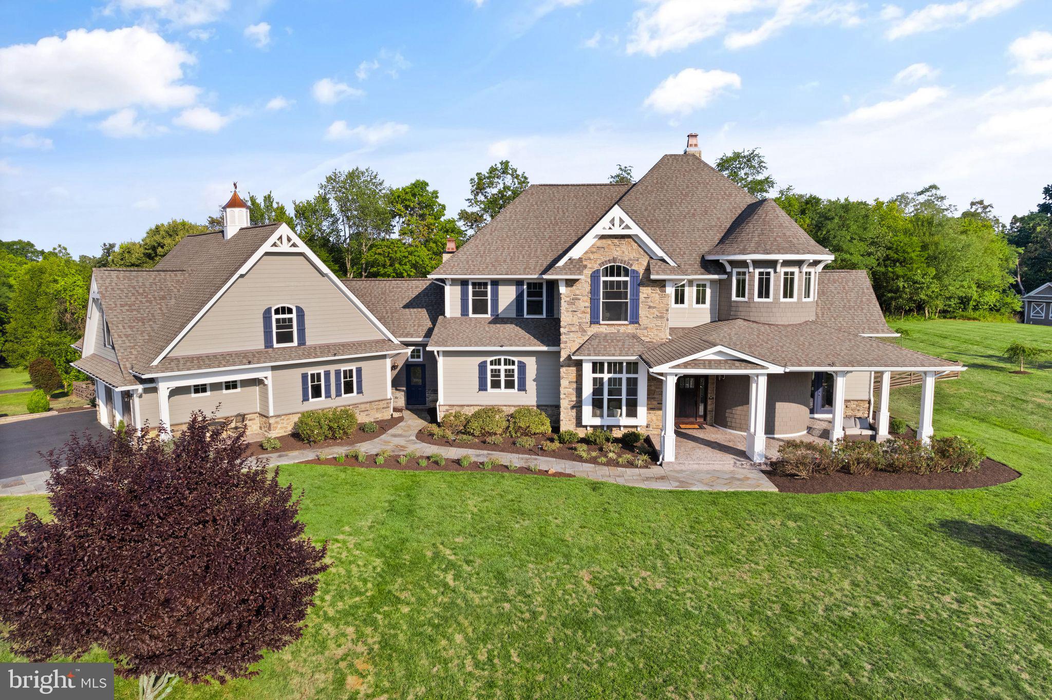 APPOINTMENT ONLY!  Please do not show up without appointment.
WELCOME HOME! Overlooking Bull Run Mountain, this custom Craftsman-style estate is situated on 10 picturesque acres in the Evergreen Estates Community of Haymarket. Enjoy the perfect blend of refined elegance and natural beauty in this exceptional property. Located in Western Prince William County, this home offers the tranquility of country living with easy access to modern conveniences, including commuter routes, shopping, dining, healthcare facilities, and local attractions like vineyards and breweries.

Built in 2015, with recent remodeling throughout along with extensive landscaping,  this charming home is perched atop a hill crest, providing stunning panoramic views of the mountains and the beautiful Virginia countryside. The back of the property features dense trees, walking and ATV trails, a brook, and several tree stands. The abundant wildlife, including deer, foxes, and various bird species, enhances the serene atmosphere. The contemporary-style turret and distinctive rooflines make a striking impression as you approach the cul-de-sac.

This amazing home features 6 bedrooms and 6 full bathrooms across three levels, including a separate garage apartment with its own kitchen and living area. The main level boasts a master bedroom suite with a luxurious bathroom and ample privacy. The breathtaking 3-story winding staircase in the turret, extensive wood trim, columns, shadow boxes, and hardwood floors add timeless elegance throughout.

The dining room offers a view of the open foyer, perfect for entertaining. A private office with serene mountain views is located behind the staircase. The Great Room, filled with natural light from walls of windows and sliding glass doors, opens to a covered porch with a fireplace and a private lanai with a hot tub. The space also features a striking gas fireplace with an ornate mantel.

The gourmet kitchen is a chef’s dream, equipped with top-of-the-line stainless steel appliances, quartzite countertops, a ceramic tile backsplash, and a pot filler. A butler’s pantry and walk-in pantry with an extra refrigerator provide extensive storage. The adjacent laundry room and mudroom/breezeway connect to the garage, featuring a shower for easy cleanup after outdoor activities.

The oversized 3-car garage offers additional storage space, while the upper level includes 3 bedrooms, 2 bathrooms, and a large gathering room suitable for a game room, home theater, or office. The lower level features a spacious family room, wine cellar, gym, bar, card table area, and dedicated spaces for ping pong, pool, and air hockey. An additional bedroom, full bath, and dual storage areas complete this level.

This estate home combines luxury and functionality, offering a year-round vacation experience with unmatched comfort and convenience.