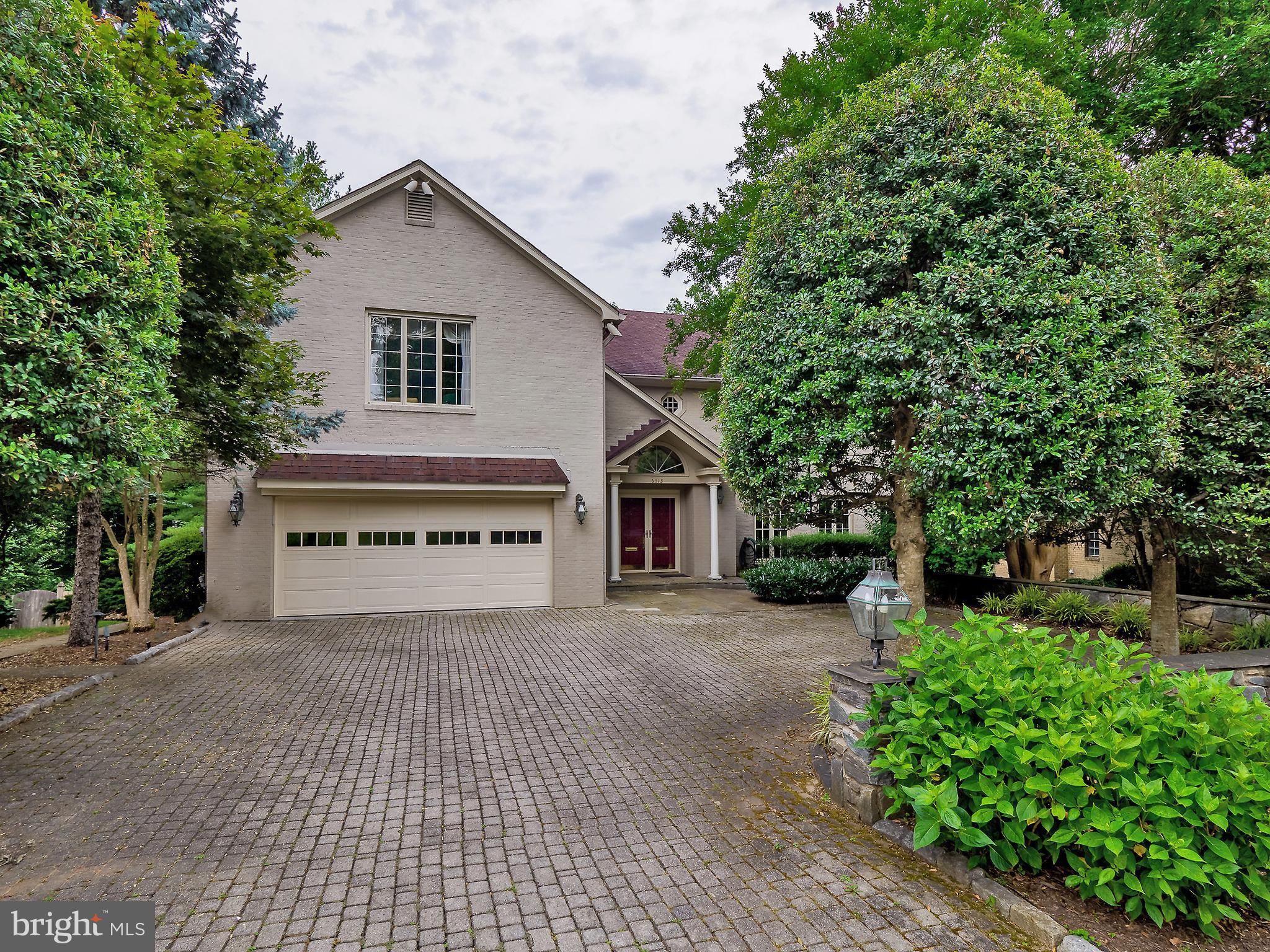 This stately residence with an inground pool offers nearly 8,000 square feet and blends timeless architecture with exceptional craftsmanship. Truly move-in ready, the home makes a striking first impression with a dramatic two-story marble foyer and statement chandelier.

The main level features soaring ceilings, rich hardwood floors, detailed moldings, and custom window treatments throughout. Designed for both grand entertaining and everyday living, the open floor plan includes a formal living room with fireplace and expansive windows, flowing seamlessly into the elegant dining room with custom built-ins and wet bar.

The gourmet eat-in kitchen is outfitted with a large center island, granite countertops, stainless steel double wall ovens, two dishwashers, and a secondary refrigerator — ideal for hosting. Just off the kitchen, the spacious family room is wrapped in windows on three sides, offering abundant natural light and tranquil views of the private rear grounds.

A refined mahogany library with custom built-ins and fireplace, powder room, laundry room, and oversized two-car garage complete the main level.

Upstairs, the expansive primary suite offers a sitting area with fireplace, generous walk-in closets, and a luxurious spa bath featuring a soaking tub, dual vanities, and separate shower. Three additional well-appointed bedrooms each include updated en-suite baths.

The fully finished, walkout lower level is expansive and versatile, featuring an in-law suite with full bath, fireplace, wet bar, wine cellar, additional bedroom, recreation space, and abundant storage.

Walls of sliding glass doors open to a private backyard retreat with a stunning in-ground pool and stone terrace — a true outdoor oasis.

Ideally located just minutes from downtown Bethesda’s shops, dining, and conveniences, with easy access to Washington, DC, Northern Virginia, and major commuter routes, this exceptional property also offers proximity to parks and recreation.