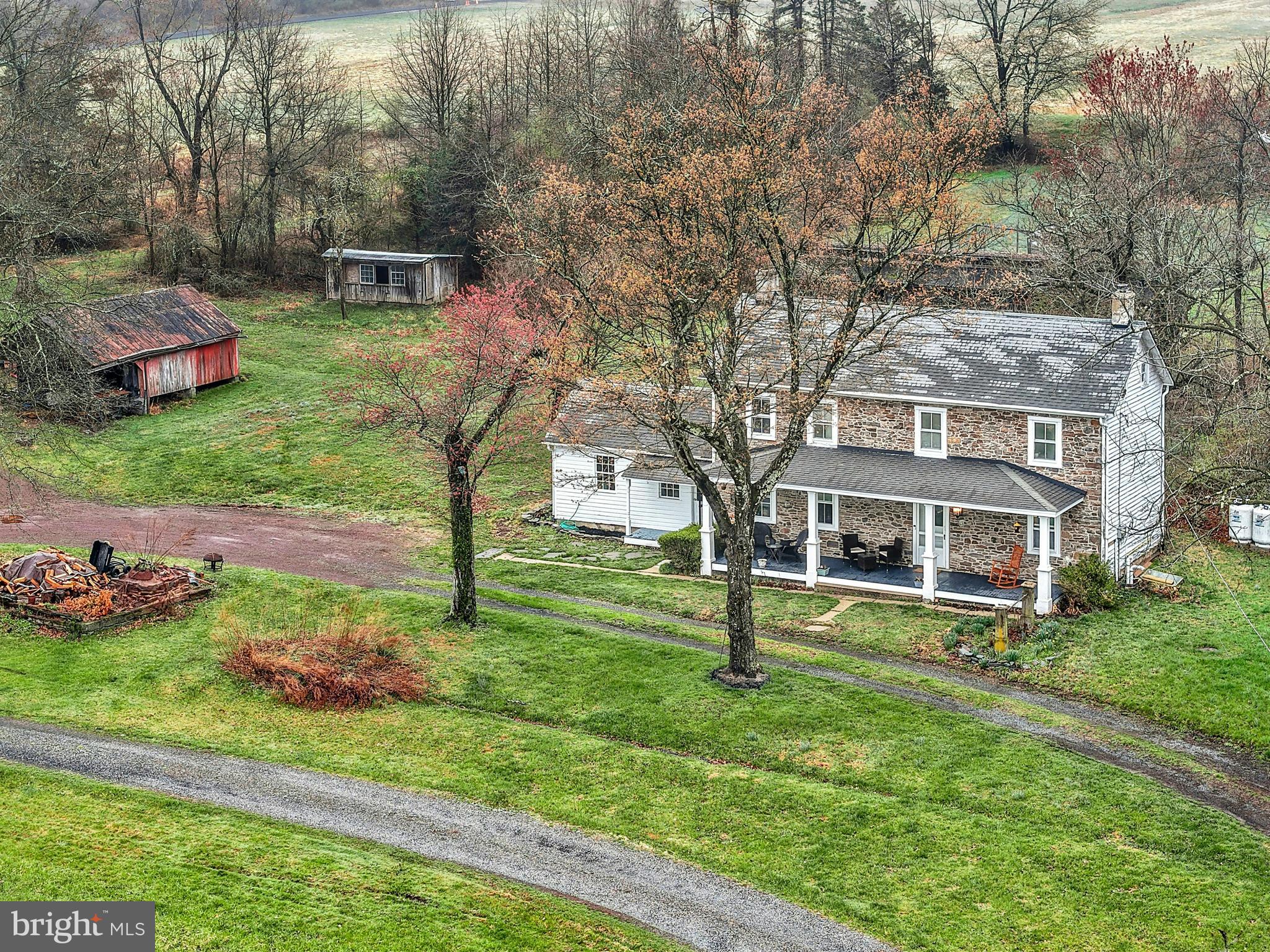 Wide skies and tall trees frame this incredible 12 acre homestead on a quiet country road in Bucks County. 
     Set far back from the road, the classic 1790 stone farmhouse reminds one of a slower, more intentional life. Panoramic views make the covered front porch a lovely place for morning coffee or evening drinks with friends. Inside, the home is cozy, with deep silled windows with rounded cheeks throughout, and a wood burning stove in the living room. The eat-in kitchen is sunny and well-appointed, with room for a table and chairs.  Adjacent, the mudroom and workroom provide storage or hobby space.
     Upstairs, a  primary suite is joined by two additional bedrooms and a hall bath. Access to an unfinished third floor offers an opportunity for additional living space.  Wood floors are found on each level.   The laundry is located in the tidy lower level, along with additional storage space.
     This exceptional property and location presents an unparalleled opportunity which will appeal in a multitude of ways.   As is for a serene rural retreat or as a historic backdrop for expansion and embellishment befitting the location and setting.    Located in the Central Bucks School District.