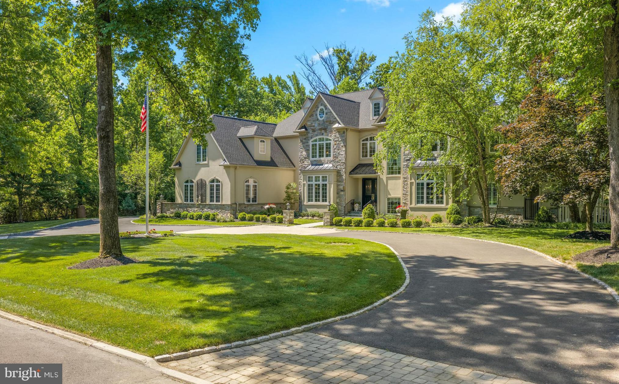 Some homes are built to sell. This one was also built to last — a testament to the art of custom homebuilding by the celebrated firm Philomeno & Salamone, conceived from the ground up as a generational estate where every detail tells the story of true craftsmanship. Set at the end of a tree-lined cul-de-sac in the coveted Whitemarsh section of Blue Bell, on a lush, private acre of manicured grounds, this is a residence that announces itself quietly and delivers endlessly.  Peace of mind is foundational here. Meticulous stewardship over the years is evident in a newer roof, mechanicals, and a comprehensive full stucco remediation completed in 2014 — the kind of responsible ownership that only deepens the value of a forever home.  A soaring two-story foyer sets the tone: natural light cascades through generous windows, illuminating the custom millwork that is the home's quiet signature throughout. The traditional floor plan flows with rare intentionality — from a step-down formal living room anchored by a floor-to-ceiling fireplace, through an elegant formal dining room, and into a generous open family room with a built-in bar, fireplace, and custom cabinetry designed for the way families actually live and entertain.  The kitchen is a study in thoughtful design: a butcher block island at its heart, double ovens, a butler's pantry, and a dedicated message center that speaks to the home's role as a true family command center. Adjoining it, the morning room is nothing short of magical — a masonry fireplace, vaulted ceiling, and exposed beams create a sanctuary for quiet mornings and long evenings alike. A powder room, mudroom, and first-floor laundry complete the practical genius of this level.  The first-floor primary suite is a rare luxury: a serene retreat with a sitting room, fireplace, spa bath, and walk-in closet — offering true single-level living without compromise.  Upstairs, a cozy library invites lingering.   A second primary suite — appointed with a coffee bar, dedicated dressing area, two walk-in closets, and a private office — speaks to the kind of multi-generational flexibility that makes a home truly timeless. Three additional bedrooms and two full baths round out this level, with a staircase continuing to a vast unfinished third floor, ripe with possibility.  The fully finished lower level is a world unto itself: a sixth bedroom and full bath, a kitchenette, a full gym, a craft room, and a playroom ensure that every chapter of family life — and every guest — is accommodated in style.  Step outside to a private outdoor sanctuary: lush, layered landscaping frames elegant paver terraces, a sparkling pool, and a bocce court — a nod to the gracious entertaining lifestyle this home has always supported. The generator and three-car garage complete the picture of an estate engineered for both beauty and function.  Homes like this do not wait — schedule your private tour today