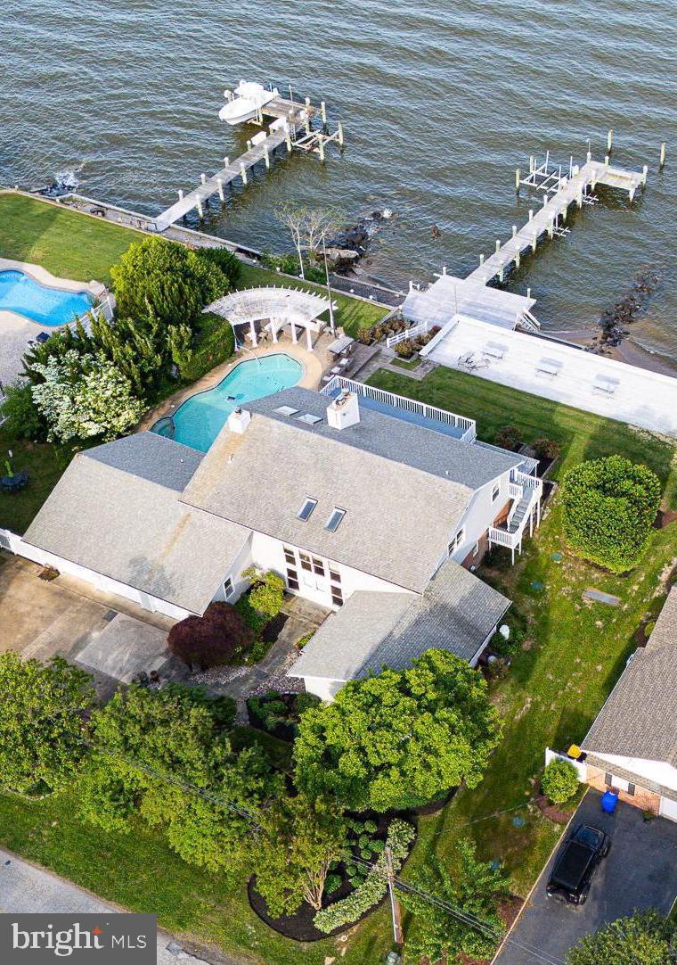 The location of this property is fabulous! One of the most beautiful spots on the bay, it features a panoramic  view  across to Annapolis! Watch the ships going in and out of Baltimore, magnificent sunsets, and the Blue Angels when they perform!
In a small neighborhood, just minutes from the Bay Bridge, the property has all you need for a year-round home or for a week-end or vacation retreat! The cement, heated in-ground pool adjoins the deck and porch areas . The private pier accommodates a boat lift and two jet-ski lifts.  Depending on the tide, there is a beach! 
This uniquely-designed home offers multiple living and dining areas, as well as main and second level bedrooms and a separate office. With its many  three-season and screened-in porch areas and outside decks, you can entertain rain or shine! 
And, by the way, the golfers in the family, need not leave the neighborhood as it abuts the Blue Heron Golf Course! 
Instead of commuting from your primary home to a vacation home, save yourself the trip...this house has it all!
There is a video security system at the property.