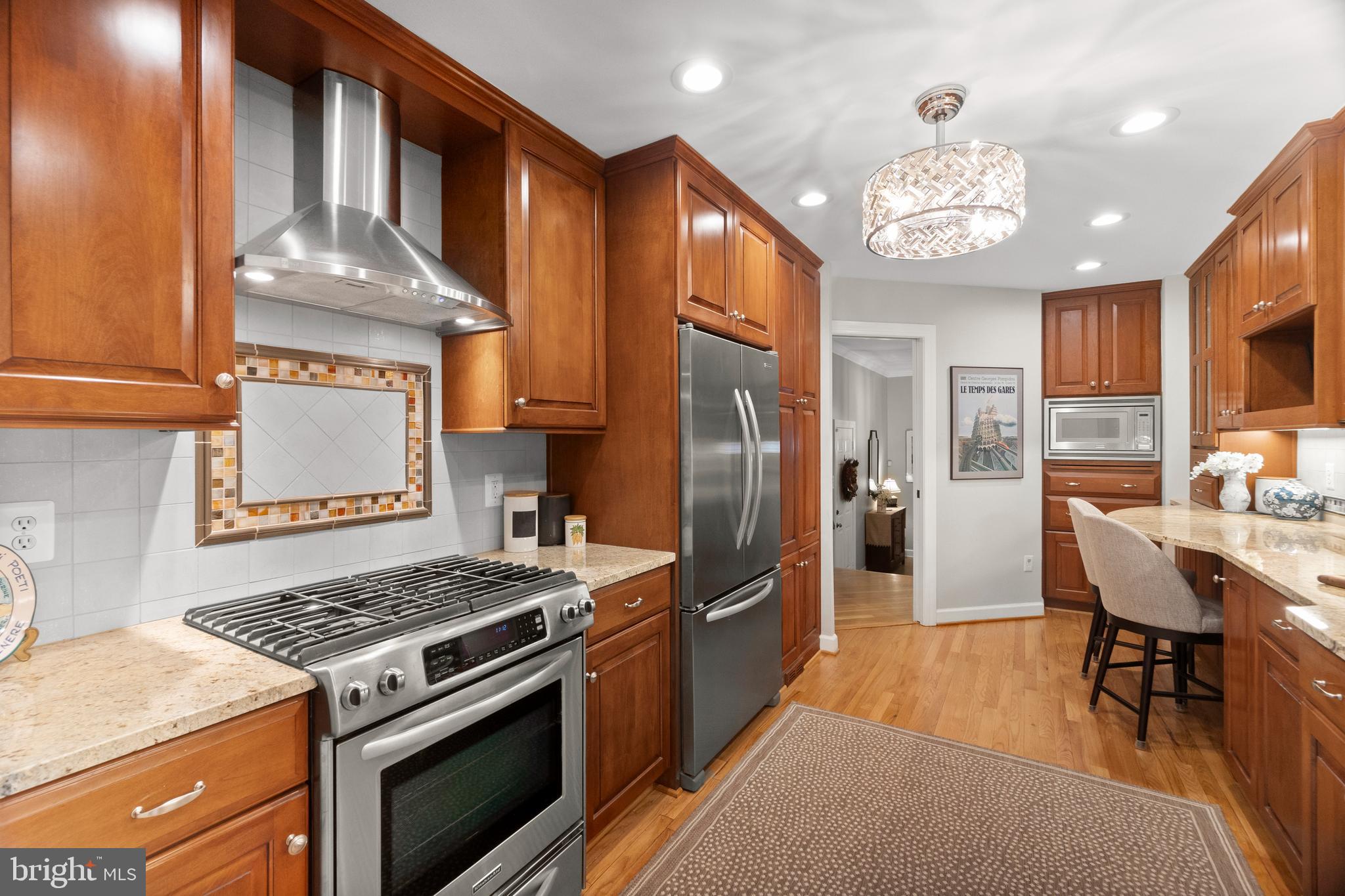 Welcome to 6315 Chaucer Lane, a nicely upgraded 3 bedroom, 3 full bath, 1-car garage TH with 3035 finished sq.ft.  This TH is in the Landmark Mews community located at the West End of Alexandria. The Community offers a Park-like setting, while still providing immediate access to 395/Beltway/95, with proximity to the Pentagon, DC, Reagan National airport, and Old Town Alexandria.  Landmark Mews is 5 minutes from the $2.2 Billion WestEnd Alexandria development project, which will include the new Inova Alexandria Hospital Campus.  This combination of house, Community, and location features are rarely found Inside the Beltway.

To learn more about Landmark Mews, check out the Property website/virtual tour and the Listing Agent's Living in Landmark Mews website.  If you are viewing the non-branded version of the Property website, ask your agent for the URLs to both the branded Property website (for the Community and WestEnd Alexandria project videos) and the Living in Landmark Mews website, which is a comprehensive source of visuals and information on choosing the Community as your Home.  The Landmark Mews website also includes the referenced Community video with spectacular aerial views and videos/info on restaurants, shopping, and other "Livability" benefits from proximity to everything.

House Details: This four-level home has upgrades throughout, both inside and exterior, which make this house truly move-in ready to enjoy as your new home. A curved brick walk leads to this brick front TH.  The front landscaping is designed and installed by Merrifield Garden Center. From the front door, you are a 30-second walk to the 1-acre central Commons in the Community with walking paths, benches, and mature trees and landscaping. The home opens to a tiled entry with a 12-foot ceiling, then on to the beautifully remodeled kitchen with added cabinets, granite counters, newly refinished wood floors, and stainless appliances with a stainless hood over the gas cooktop. The Living and Dining Rooms on the Main Level have wood floors laid on the diagonal.  A wood burning fireplace is located in this area.  The deck is accessed from the Main Level through an upgraded slder door.  The deck steps down to a paver patio.  The rear area is surrounded by a recently stained fence. The half bath on the Main Level has been fully remodeled. The bedroom level has two Owner's Suites, each sized to make a King bed look small.  Both bedrooms have en suite bathrooms with a large walk-in closet. The 1st Owner's Suite has a beautifully remodeld bathroom with high-end featues and finishes, including a large walk-in shower & heated floor.  The walk-in closet for this bedroom has a California Closet storage system. The 2nd Owner's Suite is currently set up as an Office.  The en suite bathroom is also nicely remodeled in full. The Upper Level has the 3rd bedroom, with a walk-in closet.  The 3rd full bedroom serves this bedroom.  This level has two large walk-in attic storage spaces. The Lower Level has the 2nd fireplace, full bar with granite tops, an upgraded 2nd half bath, & the laundry room.  This level has a walk-in storage area. All light fixtures in the house have been upgraded. All house windows are Pella replacement windows. The house has a central vacuum system. The garage has an epoxy floor covering. The HVAC systems are 2014 and 2016. The water heater was installed in 2022.  
The roof was installed in 2011.