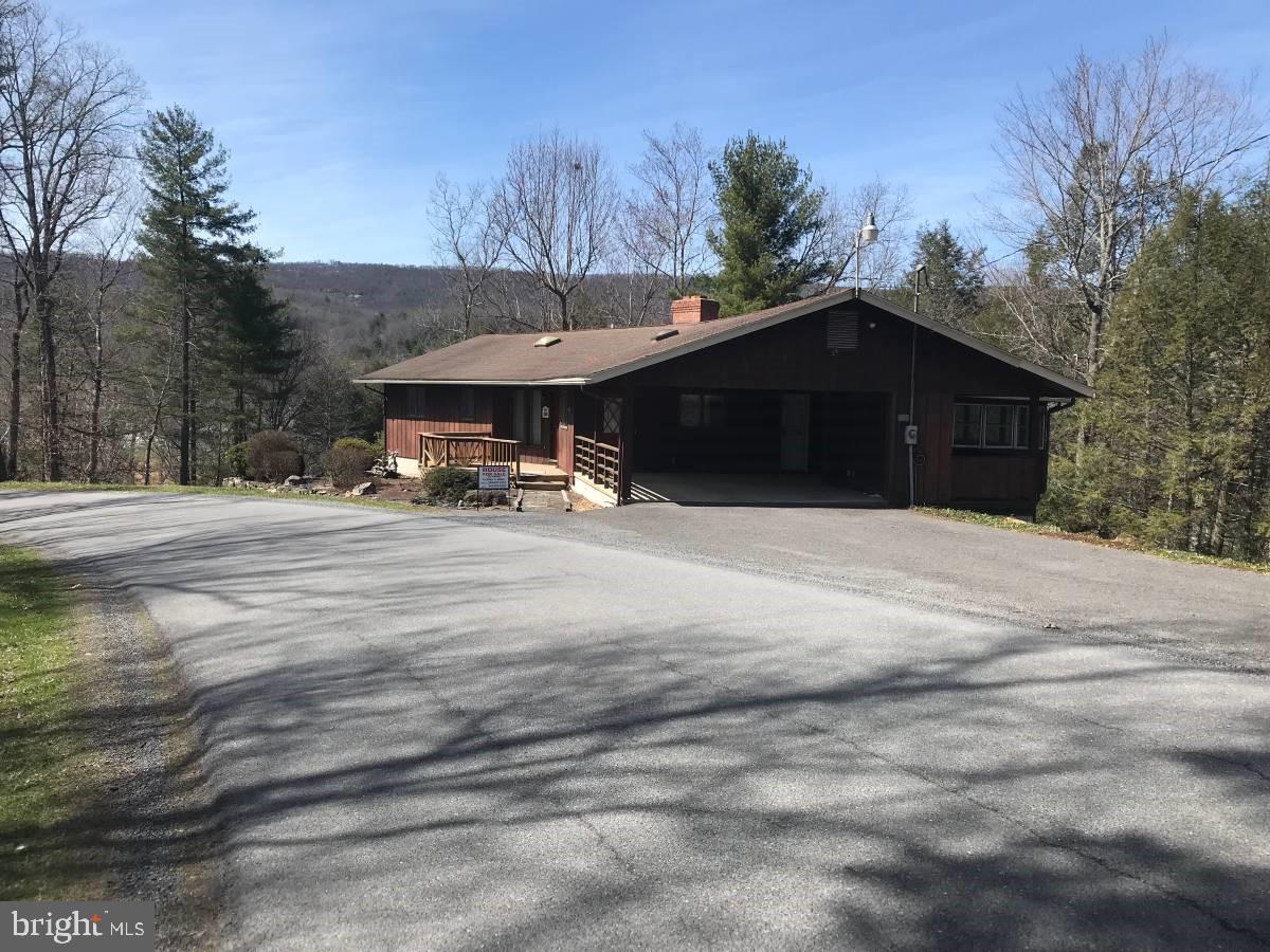 Have you ever wanted to live in Wild, Wonderful, West Virginia? Well here is your golden opportunity to achieve your dream.

We are selling a unique, one of a kind family home ideally situated overlooking a very private canyon with a beautiful year around stream below. Our home was custom built in 1980 by one of the premier builders in Pendleton County. Our parents were the only owners of this solidly built home that has been well maintained.

It enjoys a private, out of town feel, but has an in town feel within walking distance to the grocery store and downtown in mintues.

Some features are as follows:
*2 level home, fully finished downstairs which could also be converted into a mother in law/rental apartment
*Lot size is 1.83 acres
*4 bedroom (2 upstairs and 2 downstairs)
*2 full baths, 1/2 bath off master bedroom
*Approximately 2700 square feet
*Large closets for storage
*Anderson windows throughout
*Heat pump with propane gas furnace, electric hot water heater, air conditioning, and small pot belly stove
*Large living room and dining room with beautiful stone fireplace
*Kitchen has refrigerator, new electric stove, microwave and dishwasher with spacious oak cabinets
*Large laundry room with washer and dryer and double washed sinks
*Large workshop with refrigerator, shelves, and exit door to the back lower level
*Separate sewing room with spacious cabinets along one wall with closet
*Separate pantry room
*Central vacuuming system throughout the house
*Full attic with storage
*Nice fully covered two car carport on the same level as the upstairs main floor
*Attractive deck outside the front door entrance
*Beautiful screened in sun room with storm windows overlooking the canyon and stream below
*Ledge overlooking the canyon which could be an ideal place for a gazebo and/or fire pit for outdoor relaxation