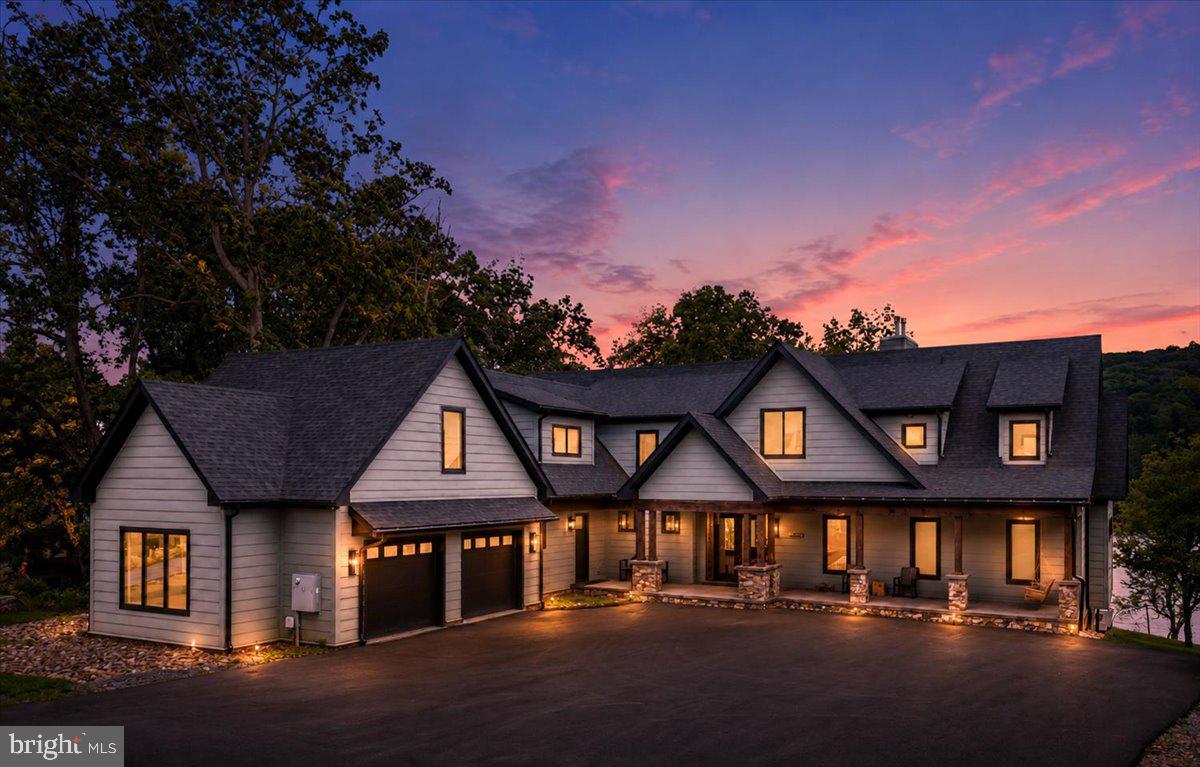 Welcome to "Stone Manor", one of Deep Creek Lake's most extraordinary waterfront estates.

Custom built in 2023 by renowned builder Don Nemith and beautifully curated by Juniper Interiors, this remarkable lakefront retreat blends timeless craftsmanship, luxury design, and exceptional investment potential. Situated on nearly an acre with 108.9 feet of level lake frontage and a coveted Class A private dock, the property offers over 8,300 square feet of thoughtfully designed living space in one of Deep Creek Lake's most desirable locations.

Paying homage to the property's rich history, the owners incorporated stone from the original Stone Manor into the construction and landscape design, creating a one-of-a-kind residence that honors the past while delivering every modern luxury imaginable.

Inside, you'll find 5 bedrooms, 6 full baths, 1 half bath, soaring ceilings, expansive gathering spaces, designer finishes, and walls of glass that frame breathtaking lake views throughout the home. The spectacular indoor pool creates a true four-season resort experience, while multiple indoor and outdoor entertaining areas were designed for unforgettable gatherings with family and friends.

The exterior is equally impressive, featuring extensive custom hardscaping, an outdoor kitchen, multiple lakeside entertaining spaces, and easy access to the private dock just steps from the home. A massive 4-car garage provides exceptional space for vehicles, boats, lake toys, and storage.

Currently operating as the highly successful Stone Manor vacation rental, the property has generated an average of $201,000 in annual gross rental revenue, offering established income potential alongside luxury lakefront ownership.

One of the few newer luxury homes on Deep Creek Lake offering a Class A dock, indoor pool, and proven six-figure rental history, Stone Manor presents a rare opportunity to own a private waterfront resort in the heart of Deep Creek Lake. Conveniently located just minutes from Wisp Resort, golf, marinas, restaurants, and year-round recreation.

Offered fully furnished and turnkey. Shown by appointment only. Call today for your private tour.