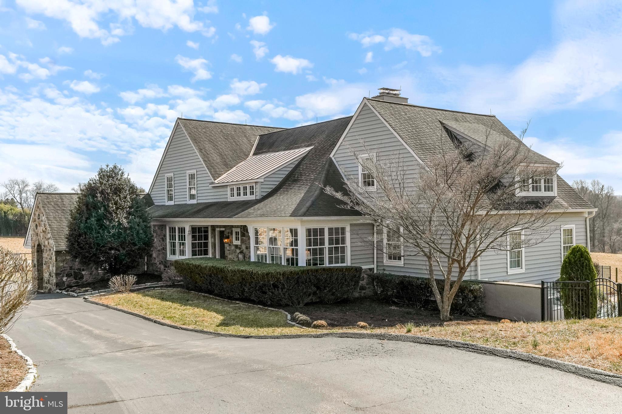 This exceptional Archer & Buchanan-designed home offers a perfect balance of style and functionality, set against scenic country views on 21.2 +/- acres under a Natural Lands conservation easement. Upon entry, the resort-like living room welcomes you with its board and beam ceiling and stone fireplace.  The windows throughout frame the picturesque landscape and allow abundant natural light. The chef’s kitchen, with extensive cabinetry and a sunny breakfast area, connects seamlessly to the intimate dining room and spacious porches and patios—ideal for relaxed entertaining.
Thoughtful amenities cater to today’s lifestyle. A private, well-lit office with custom cabinetry provides a perfect work-from-home space. The main-floor primary suite is a luxurious retreat featuring walk-in closets and continuous country views. Upstairs, three additional bedrooms offer flexibility, with one en-suite bath and two sharing a Jack-and-Jill bath. Each has generous closets plus bonus closets, including a convenient cedar closet.
The lower level adds even more functionality, including an entertainment or exercise room with a walk-out to the pool area and gardens. There is a possible 5th bedroom (if needed) with a full bath, plus ample storage areas.
The equestrian and hobbyist features of the property are also numerous. The manageable barn (built by King Construction) includes six large box stalls, a wash stall, a heated tack room (with powder room), and hay storage. An updated apartment above the barn features a kitchen, living room, bedroom, and bath. It has its own entrance and its own outside deck.   Additionally, the property has four lush pastures, a riding ring (85’x208’), and easy access to nearby 1200+ acre LenFest Preserve for scenic riding trails in Radnor Hunt country. The four-car garage with a large workshop is conveniently located near the home and has matching stonework to tie it to the home's design.
Nestled within the prestigious Unionville-Chadds Ford School District and minutes from West Chester Boro, this property combines the best of country living with modern convenience yet is very manageable.  It’s an exceptional opportunity for those seeking a refined, active lifestyle—an invaluable find in today’s market.