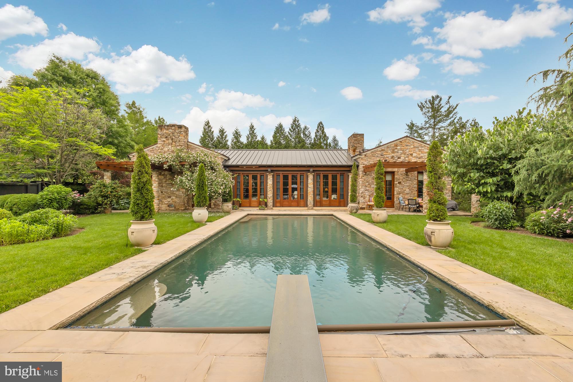 A residence reimagined; A short stroll from Potomac Village, nestled on just under 1 acre of magnificently designed grounds by Lila Fendrick, sits a Tuscan Villa. Originally designed as a pool house by Ann Decker, this 3 bedroom 3 1/2 bath Sandy Spring Builders renovation won the 2021 “MBIA gold custom home renovation award.” Every detail in the original design and renovation was meticulously regarded, from the imported limestone to the English greenhouse, from the beautiful mahogany built-ins to the Jennifer Gilmer designed kitchen with La Cornue CornuFe range. The oversized in ground pool sets the stage for a retreat of relaxation and renewal. Absolutely a must have for the one looking for that far away retreat within minutes of the beltway.