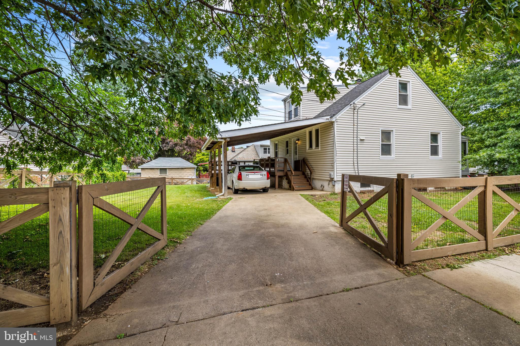 A crossbuck country fence runs along the Wood Heights sidewalk, turns tightly at Buchanan, and continues atop a stacked-stone retaining wall beneath the canopy of a spreading pin oak. Hiding behind the oak is a Medfield bungalow, its windowed porch waiting at the end of a bluestone path.
The porch, a three-season space warmed by the sun through its louvered panes, leads to an easeful and open living area. A hallway connects two corner bedrooms and a shared full bath. Upstairs, the geometry created by the parallels and intersections of the roof gables, dormers, and eaves assigns charmed functions to each of the bedroom's quadrants: a place to sleep, a place to sit, perhaps a place to work. With sunlight arriving from all sides, the planked walls evoke the quaintness of a Nantucket cottage. On the lower level, recently updated flooring and lighting redefine the knotty-pine-paneled space. There is a half bath beside the rear entrance, while utility, storage, and laundry areas occupy the unfinished opposite side. From the kitchen, one steps onto the covered rear deck, conveniently built in an L-shape around the shed-roof carport. This corner lot reveals its generous size as the yard wraps completely around the home, with lawns extending to both the side and rear.
Convenient to Cold Spring Lane, Falls Road, and I-83.