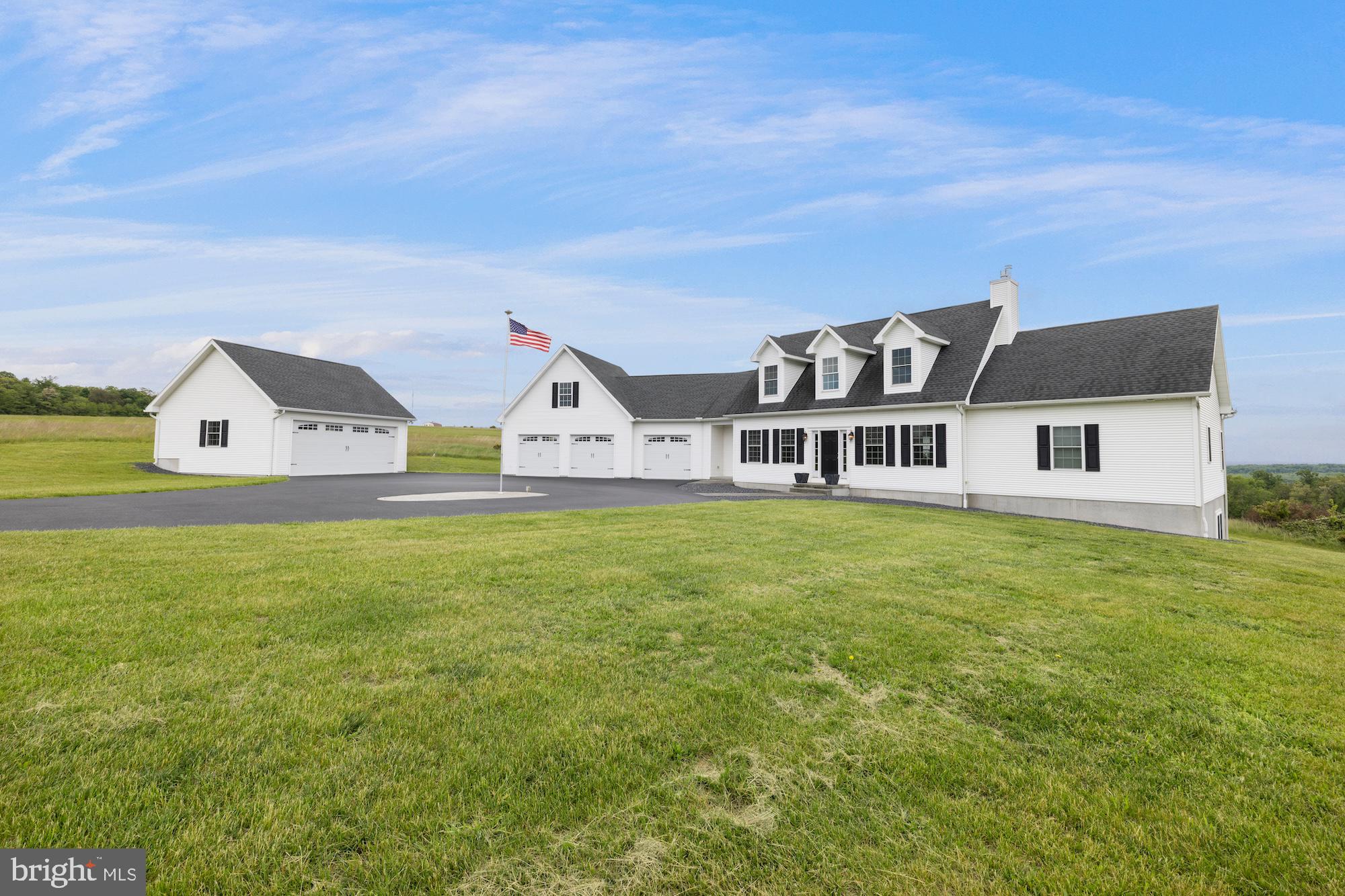 Exceptional custom-built contemporary home situated on 10+ scenic acres with stunning valley views. Built in 2016, this thoughtfully designed 3-bedroom, 3.5-bath residence offers quality craftsmanship and premium finishes throughout. The main level features beautiful hickory hardwood flooring, custom cabinetry, and built-in bookshelves that add warmth and character to the modern design.
The spacious kitchen and open living areas flow seamlessly to the outdoor entertainment spaces, including a composite deck, partially screened porch with ceiling fan, and a stamped concrete patio complete with fire pit. Enjoy recreation and relaxation with your own private bocce court and expansive countryside setting.
The full unfinished basement boasts 9+ foot ceilings, a finished full bath with ceramic tile floor, utility/storage area with utility sink, and endless potential for additional living space. Car enthusiasts and hobbyists will appreciate the attached oversized 3-car garage along with a detached 2-car garage featuring a workbench and coach-style garage door.
Additional highlights include geothermal heating and cooling, 400-amp electric service, 16 kW Generac generator, and two exterior propane hookups for barbecues and outdoor entertaining. A rare opportunity to own a beautifully crafted home combining modern comfort, efficiency, and breathtaking natural surroundings.
