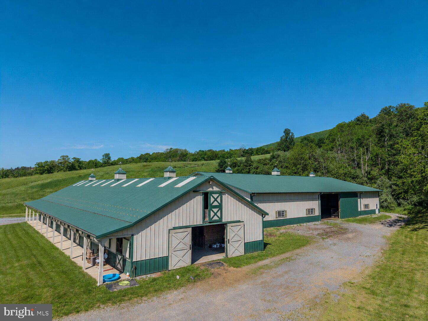 Rare 204-acre equestrian estate featuring a modern 12-stall horse barn with wash bay, tack room, feed room, and upper-level hay storage, along with 39 acres of pasture divided into six paddock. Training facilities feature an 80'×120' indoor riding arena and a large outdoor arena. The land offers approximately 58 acres of tillable ground and 133 acres of woodland, creating an excellent mix of agricultural use and recreation. Ideal for a private equestrian estate, training or breeding operation, or agricultural investment.