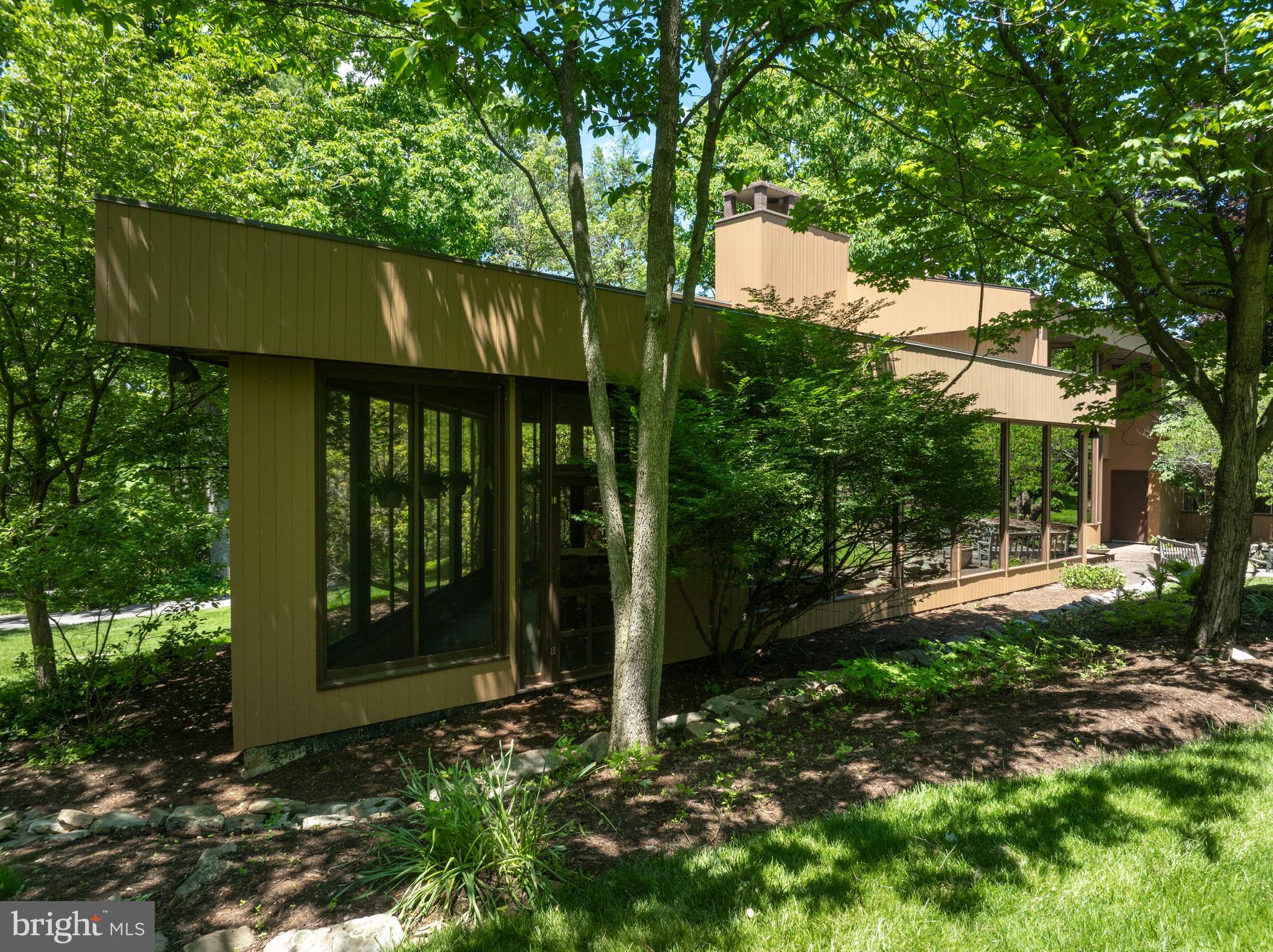 A truly extraordinary, one-of-a-kind architectural masterpiece, this remarkable residence was thoughtfully designed to bring the beauty of the surrounding landscape into every room. Set on 6.3 private acres with mature landscaping, a wraparound driveway, attached greenhouse, and a fenced garden, the property is surrounded by abundant wildlife and offers the perfect setting to enjoy the beauty of all four seasons in Pennsylvania. This is more than a house—it is a home, carefully crafted to create a sense of peace, privacy, and connection with nature.

Dramatic circular spaces, warm natural wood finishes, magnificent floor-to-ceiling bronze windows, and wide plank pegged oak hardwood floors throughout the first level create an atmosphere unlike any other. The stunning two-story foyer opens to a formal sitting room, while the expansive living room shares a striking two-sided fireplace with the elegant circular dining room, creating an unforgettable setting for entertaining. The bespoke chef's kitchen is a masterpiece of both beauty and function, featuring custom cherry cabinetry with blonde maple fronts, a Wolf gas range and ovens, Sub-Zero refrigerator, walk-in butler's pantry, spacious and functional laundry room, and an adjoining office with custom built-in cabinetry. A generous three-season room offers the perfect place to relax and take in the ever-changing views of the property.

Upstairs, the owner's suite overlooks the grand living spaces below and features a cozy propane fireplace along with breathtaking views from every direction. The owner's bath is comfortable and functional with a walk-in shower and double vanity. Through a set of glass doors, you'll discover a beautiful formal sitting room, currently serving as a private office and library. Three additional bedrooms and a shared bath complete the upper level, each offering its own unique perspective—one toward majestic Mount Nittany, another overlooking Rothrock State Forest, and the third embracing the tranquility of the surrounding woods.

Rarely does a property combine such distinctive architecture with a setting of this caliber. A true retreat where thoughtful design, natural beauty, and timeless craftsmanship come together to create a place that feels both extraordinary and deeply welcoming.