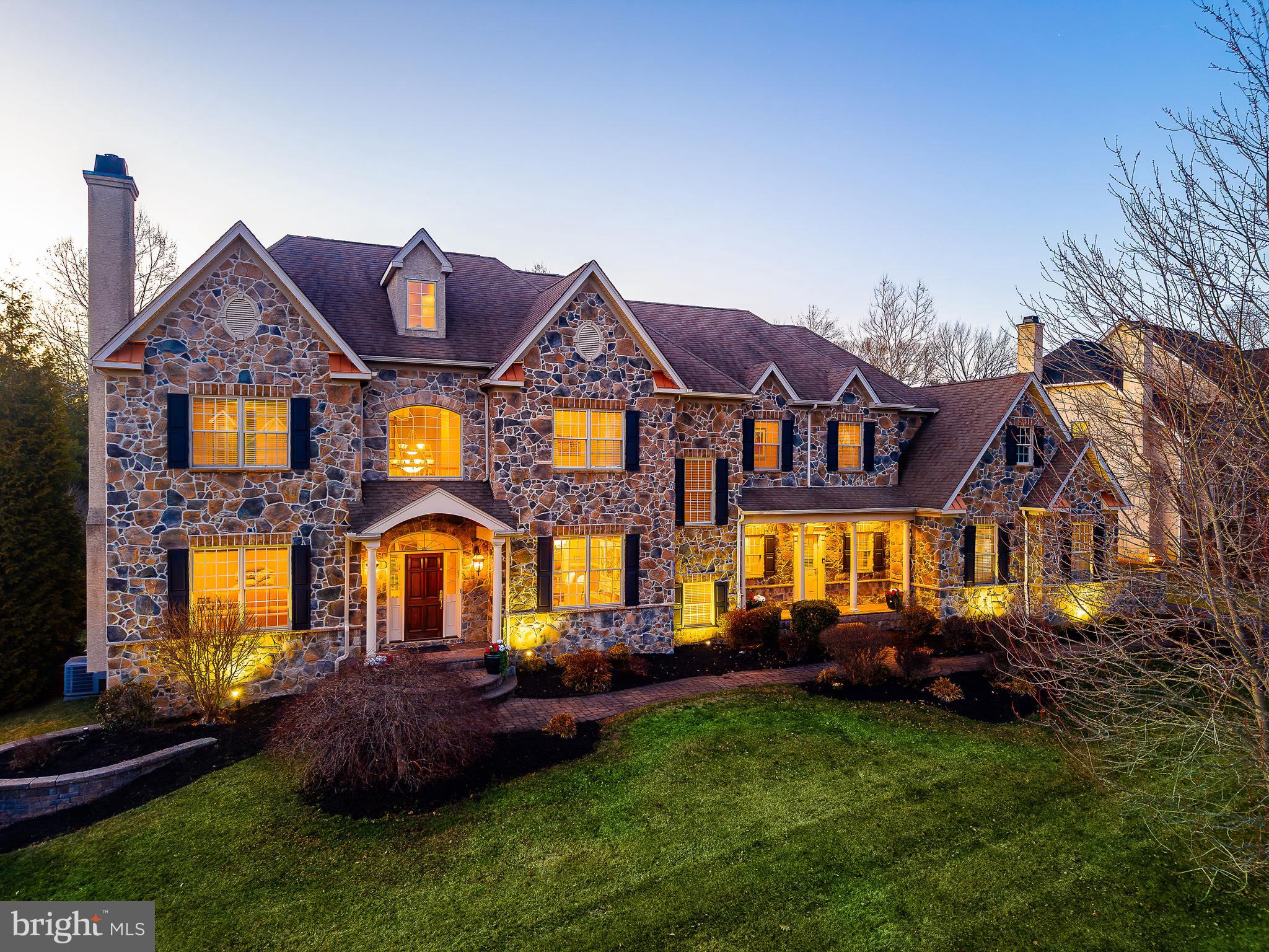 Welcome to Whitemarsh Chase, an exclusive enclave of just 20 custom-built homes by well-known local builder Sal Paone, ideally situated for convenient access to major roadways, shopping, and everyday amenities. This impressive residence offers approximately 7,000 square feet of living space across three finished levels, thoughtfully designed for both everyday living and entertaining. A grand two-story foyer sets the tone, showcasing custom tilework and introducing the home’s extensive millwork, architectural detail, and refined finishes. The formal living and dining rooms are well-proportioned for entertaining, featuring a tray ceiling and fireplace, while a private study with French doors provides direct access to the rear deck—perfect for working from home or quiet retreat. The two-story great room is filled with natural light from a dramatic wall of windows and features a fireplace and balcony overlook. The adjacent chef’s kitchen is designed for function and flow, offering granite countertops, custom tile backsplash, under-cabinet lighting, an oversized range with grill and griddle, stainless steel appliances, and a custom walk-in pantry. A sunlit breakfast room with skylight provides seamless access to the outdoor living space. The upper level features a spacious primary suite with tray ceiling, custom his-and-her closets, and a beautifully redesigned bath with spa shower and whirlpool tub. Three additional generously sized bedrooms complete this level, while the finished third floor offers flexible space ideal for a fifth bedroom, guest suite, or home office. The fully finished lower level expands the home’s versatility, offering a second kitchen, full bath, fitness area, and additional family room with movie room potential. The exterior is equally well considered, featuring a professionally landscaped setting, in-ground irrigation system, paver walkway, and an extended rear yard with TREX deck. Ideally located just minutes from I-476, the Pennsylvania Turnpike, Center City, and the airport, this home offers a rare combination of space and convenience in one of Whitemarsh Township’s most coveted neighborhoods.