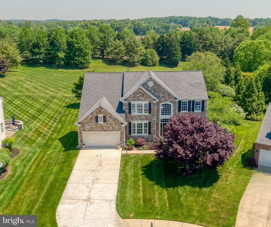 This stunning 3-level stone colonial in Stone Ridge is situated on a quiet cul-de-sac. The home offers 5 spacious bedrooms, 4.5 baths, and beautifully designed living spaces, The fully renovated gourmet kitchen (2021) features quartzite countertops, marble backsplash, custom cabinetry, stainless steel appliances and opens seamlessly to the sunroom and dramatic two-story family room. The luxurious owner’s suite includes a private sitting room and spa-like bath with a soaking tub and separate shower. The fully finished walkout lower level is ideal for an in-law or au pair suite, complete with a large bedroom, full bath, kitchenette, media room, expansive rec room, and custom office space. Step outside to a professionally landscaped yard featuring a maintenance-free deck,  paver patio with built-in grill, and stone firepit -perfect for outdoor entertaining. The lot backs to common space. Recent updates include: Roof (2024); 
Kitchen Renovation (2021); Hardwood Floors (2021); Water Heater (2021); Front Door; and Custom Office Build-Out.