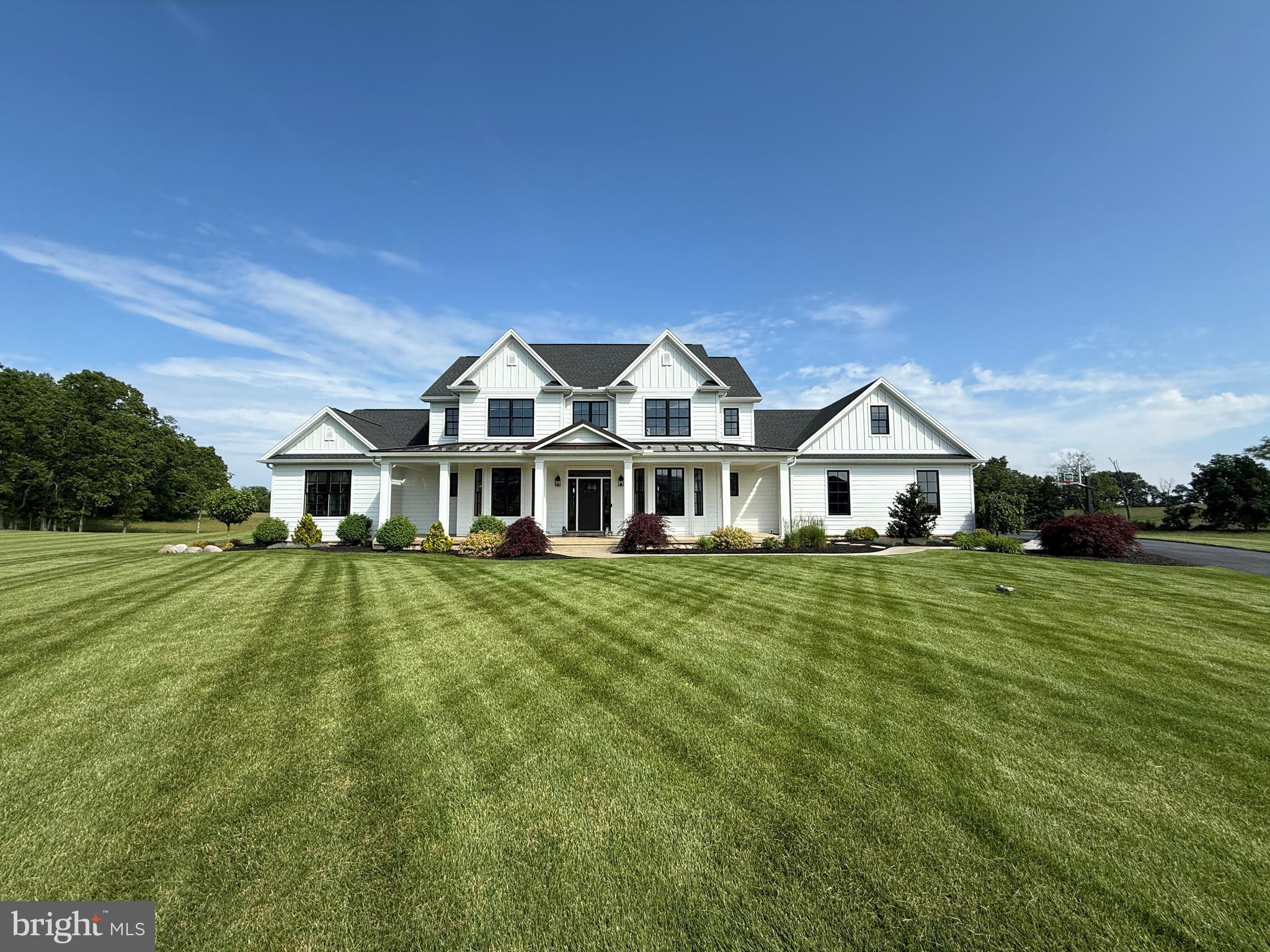 Experience the perfect blend of modern architectural farmhouse style and timeless craftsmanship in this custom-built home by Musser Homes—widely regarded as one of the area's premier builders. Prime location in "Glendale Estates" on a spacious 1.4-acre lot backing to acres of private club-owned land, this exceptional property offers breathtaking views of the Blue Mountains. The two-story great room is filled with natural light and features a stunning plank ceiling with exposed wood beams, along with a dramatic floor-to-ceiling two-sided fireplace adorned with a barn beam mantle. The first-floor primary suite is expansive, with a luxurious bath boasting a soaking tub, walk-in tiled shower and a large walk-in closet. Designed with both comfort and efficiency in mind, the home boasts 9-foot ceilings on the main level and a three-zone geothermal HVAC system.  The fireplaces and stove top are fueled by propane. The gourmet kitchen is equipped with custom cabinetry, a coffee and wine bar, a center island, and high-end appliances. There is a separate pantry and mudroom entry from the garage for convenience. The pantry also can be closed off from the kitchen for storage plus there is an area for prep and clean up. The second floor has 3 spacious bedrooms with walk in closets, two baths, loft and a large bonus room. Throughout the interior, you’ll find rich craftsman-style woodwork. There are smart home features including fire detection, security, cameras and speakers inside and out. High-end Marvin Integrity windows provide both energy efficiency and elegance. The lower level is huge with a rough-in for a bath and is awaiting your finishing touches. The exterior is stone and Hardie plank for years of maintenance free exterior.  Outdoor living is elevated with a covered rear patio featuring a see-through mountain stone fireplace with television, a separate paver patio, fire pit, a lighted in-ground trampoline and a large wraparound front porch perfect for enjoying panoramic sunsets.  Featuring superior insulation and build quality that reflect unmatched attention to detail this stunning home is perfect for your family. Call for your private tour today.