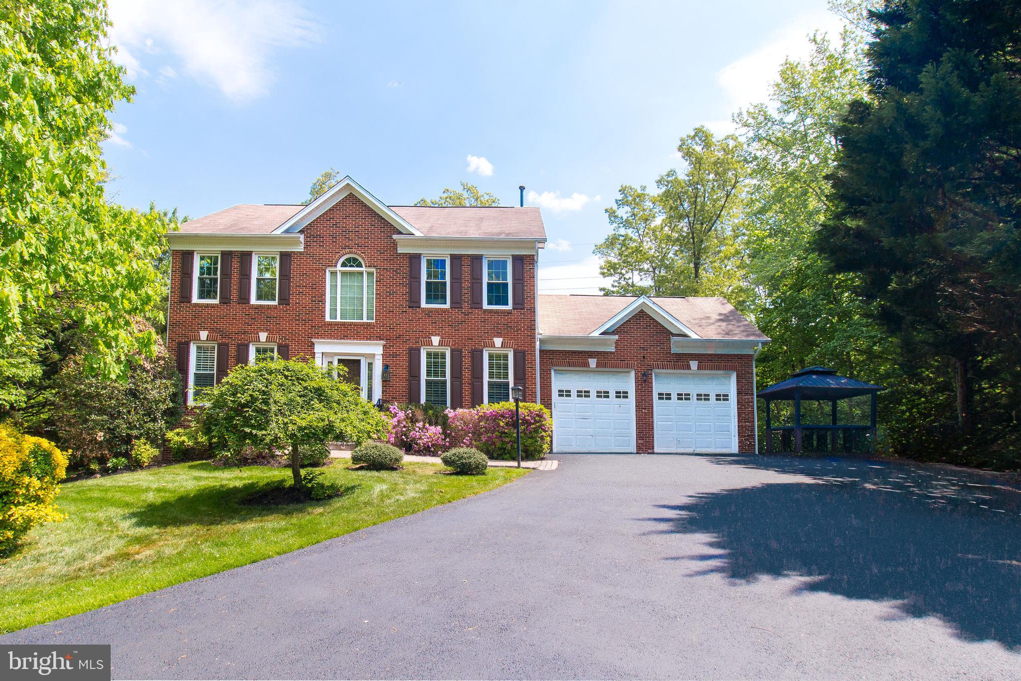 Run don't walk!!! 6 Bedroom 4 Bath, immaculately maintained Center Hall Colonial nestled in the tranquil neighborhood of Clifton—where thoughtful updates meet everyday comfort. Arrive to a long, extended driveway, a stone walkway, and mature landscaping that frames the home, beautifully. A two-car garage and additional side parking along with EV charging ports provide convenience for guests and daily living. Inside, a dramatic two-story foyer sets the tone for the home’s bright, welcoming interior. A main-level bedroom and full bath add versatility—ideal for guests, multigenerational living, or a dedicated home office. Hardwood floors run throughout the main level, complemented by formal living and dining rooms, a comfortable family room, and a gourmet eat-in kitchen with granite countertops, stainless steel appliances, and a pantry. The kitchen opens to the light-filled family room with a fireplace and direct access to the fully fenced backyard retreat with a patio, professional landscaping, hot tub, and sauna.Upstairs, the primary suite features a spa-inspired bath with custom tile, plus three additional bedrooms. The finished walk-up lower level offers exceptional flexibility for everyday living and entertaining. Enjoy a kitchenette with ample storage, refrigerator, hot plate with overhead exhaust, and dishwasher, plus a full bath, a gym/flex room (potential additional bedroom), and abundant storage. The backyard design incorporates multiple recreational features including hot tub, sauna, deck and patio area, creating spaces that facilitate both entertaining and private relaxation. Mature landscaping and wooded surroundings maintain the property's privacy and connection to nature. Extensive landscape elements, including the patio and deck configuration. underground lawn sprinkler systems. Garden with gurgling waterfall. Eenjoy your own private oasis with multiple seating areas—perfect for relaxing or hosting.