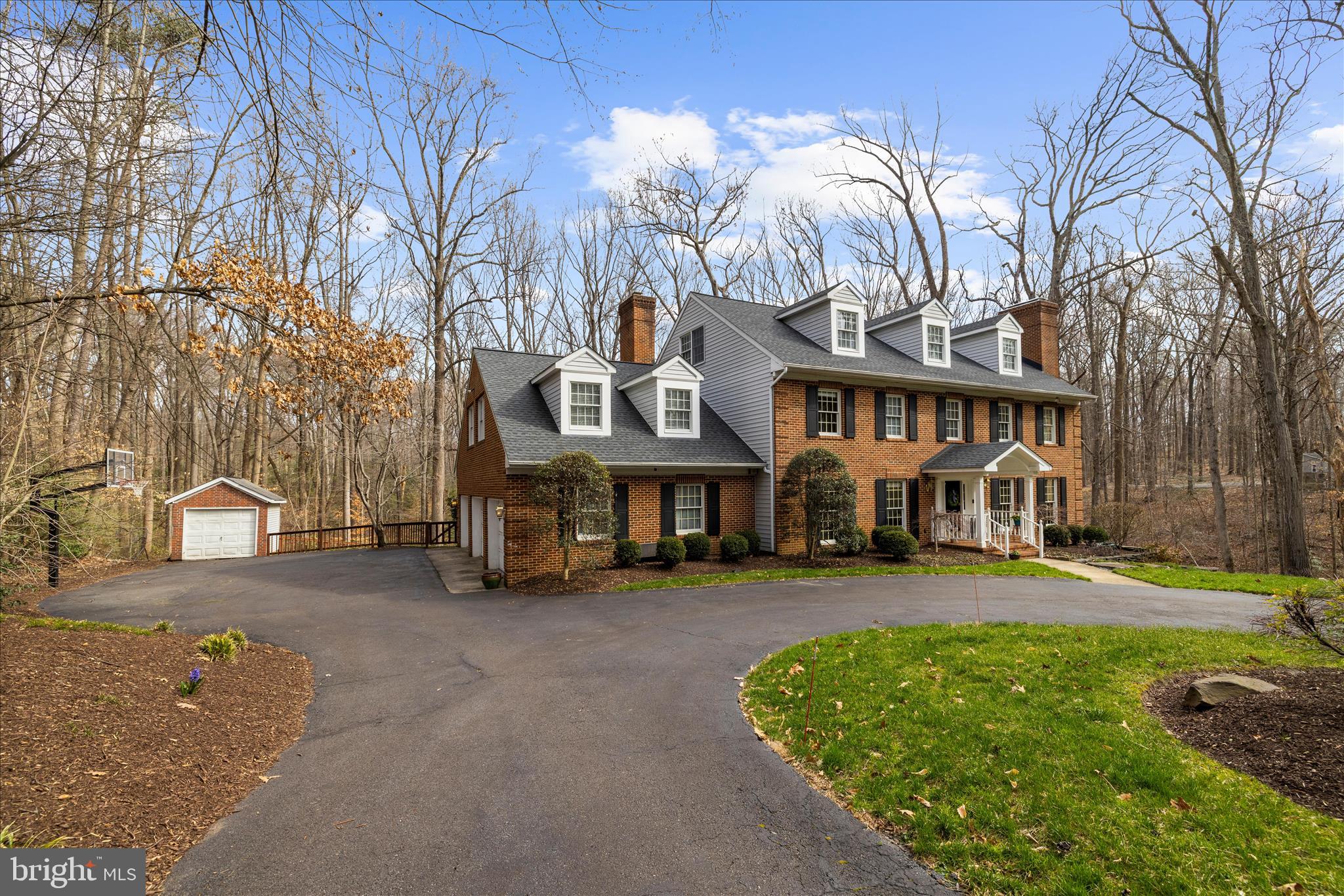 Tranquility and nature awaits you in this timeless all-brick estate, thoughtfully designed for both everyday living and MULTI-GENERATIONAL l flexibility — offering the rare feeling of living in your own private retreat while still being just minutes from the heart of Annapolis. With over 5,500 square feet, multiple private living areas, and the potential for dual primary-style suites, this home is perfectly suited for extended family living, an au pair setup, long-term guests, or evolving household needs.

A long private drive opens to a circular driveway welcoming you home to a picturesque landscape filled with mature trees and open space. Complete with a three-car garage and separate shed, there’s plenty of room for vehicles, hobbies, storage, and weekend projects.

Your home unfolds with beautifully designed living space, where hardwood floors, freshly painted interiors, abundant natural light, and generous room sizes create a warm and inviting atmosphere. The main level offers two spacious living areas, both with cozy fireplaces, a formal dining room, and a private office that could easily function as a main-level bedroom — creating additional flexibility for guests or multi-generational living needs.

The second level features four spacious bedrooms and two full baths, along with a large bonus room over the garage offering endless possibilities for a playroom, studio, secondary living area, or potential second primary suite. The expansive primary retreat is complete with its own fireplace and large private bath featuring a soaking tub, separate shower, and dual vanity.

The third upper level provides two additional bedrooms and a full bath, creating a private retreat ideal for guests, an au pair suite, or extended family.

The finished lower level adds even more versatility with a large recreation room, exercise space, abundant storage, and walkout access to a second patio leading to the generous backyard.
The lower backyard offers a secluded setting perfect for bonfires, s’mores, and evenings gathered with friends and family under the trees.
Your outdoor experience continues with an expansive deck overlooking 2.25 private acres of surrounding woodland — an ideal setting for summer dinners, quiet mornings with coffee, or simply decompressing while listening to nature. Fresh eggs await from your very own chicken coop — and the chickens can convey if buyers wish.

Perfectly positioned for your private oasis, yet just minutes from Annapolis, the Naval Academy, commuter routes, and local shopping.

A rare opportunity to enjoy space, privacy, flexibility, and nature while staying connected to everything the Annapolis area has to offer.